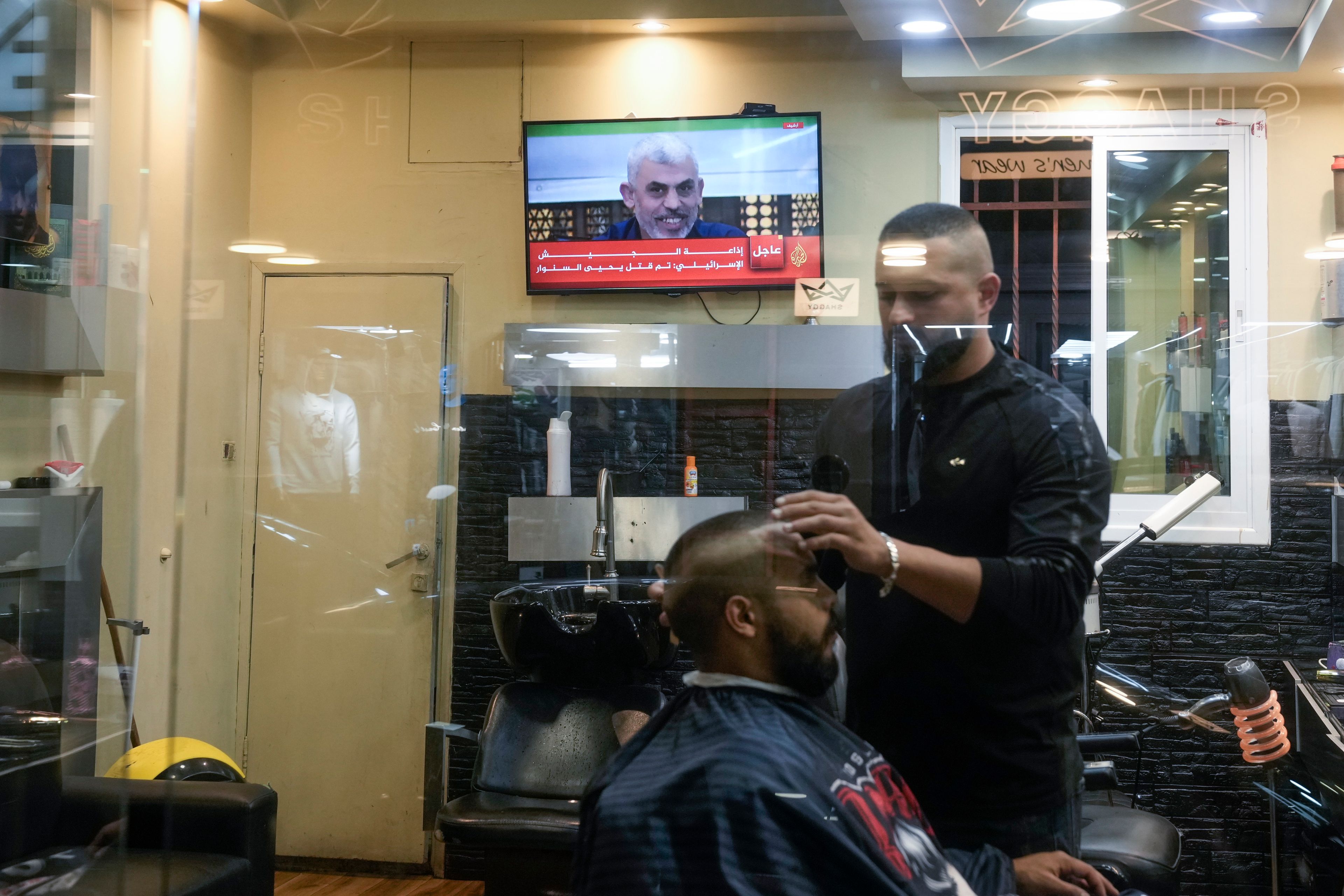 A photo of Hamas Leader Yahya Sinwar is displayed on a TV screen at a barbershop in the West Bank city of Bethlehem, Thursday, Oct 17, 2024. (AP Photo/Mahmoud Illean)