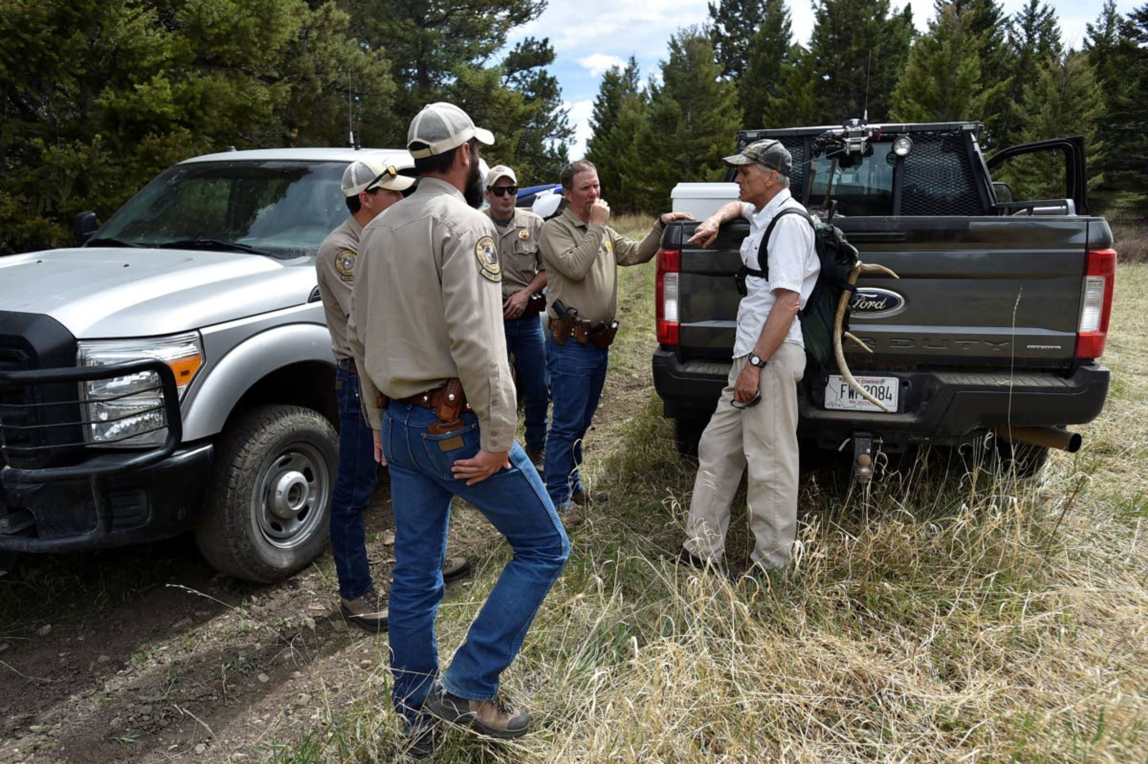 In this Wednesday, May 15, 2019 photo, Montana Fish, Wildlife and Park game wardens talk with a shed hunter at the Sun River Wildlife Management Area in Montana. (Thom Bridge/Independent Record via AP)