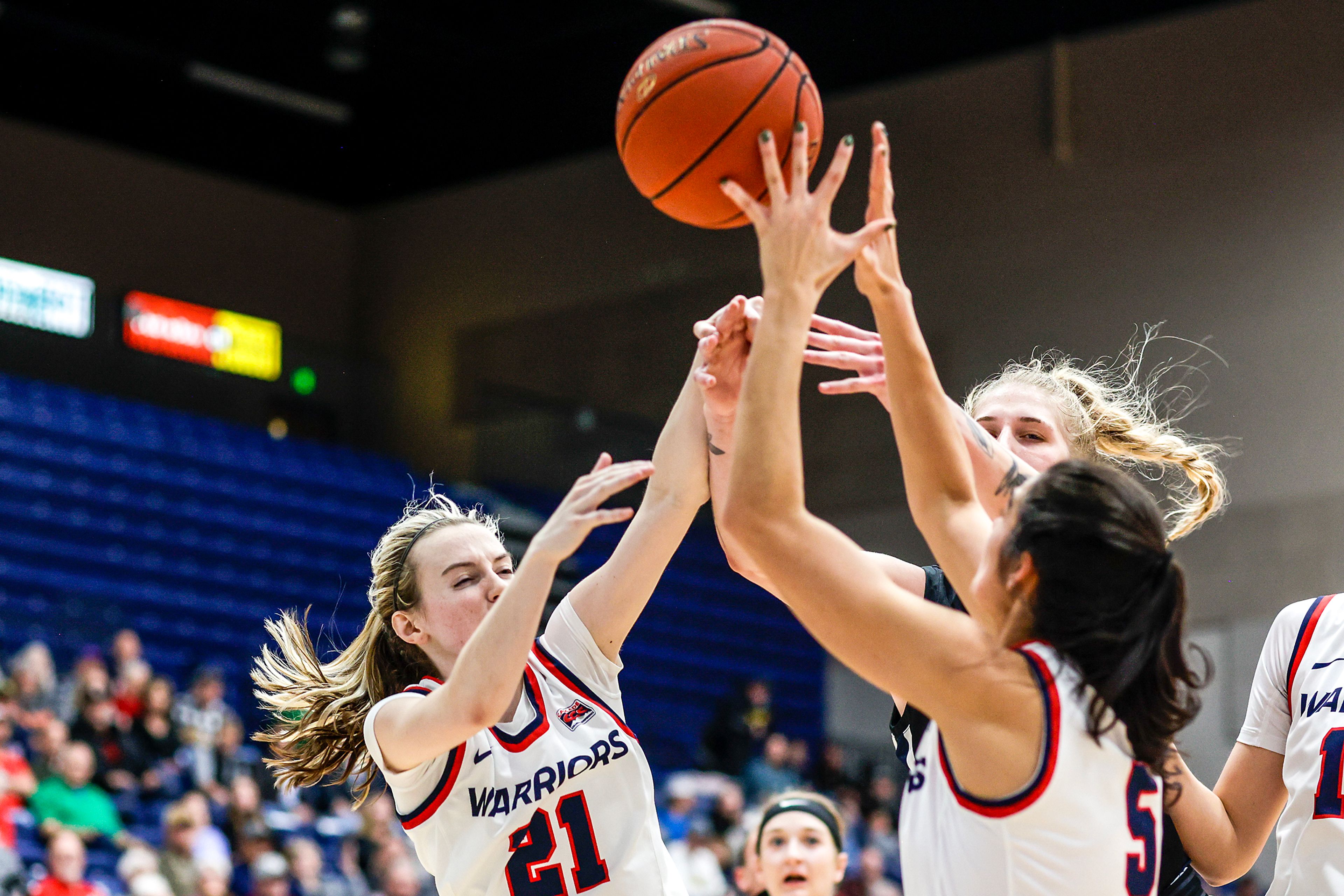 Lewis-Clark State guard Callie Stevens, left, and guard Sitara Byrd, right, fight for a rebound with Eastern Oregon forward Shaelie Burgess during a Cascade Conference game Friday at Lewis-Clark State College.