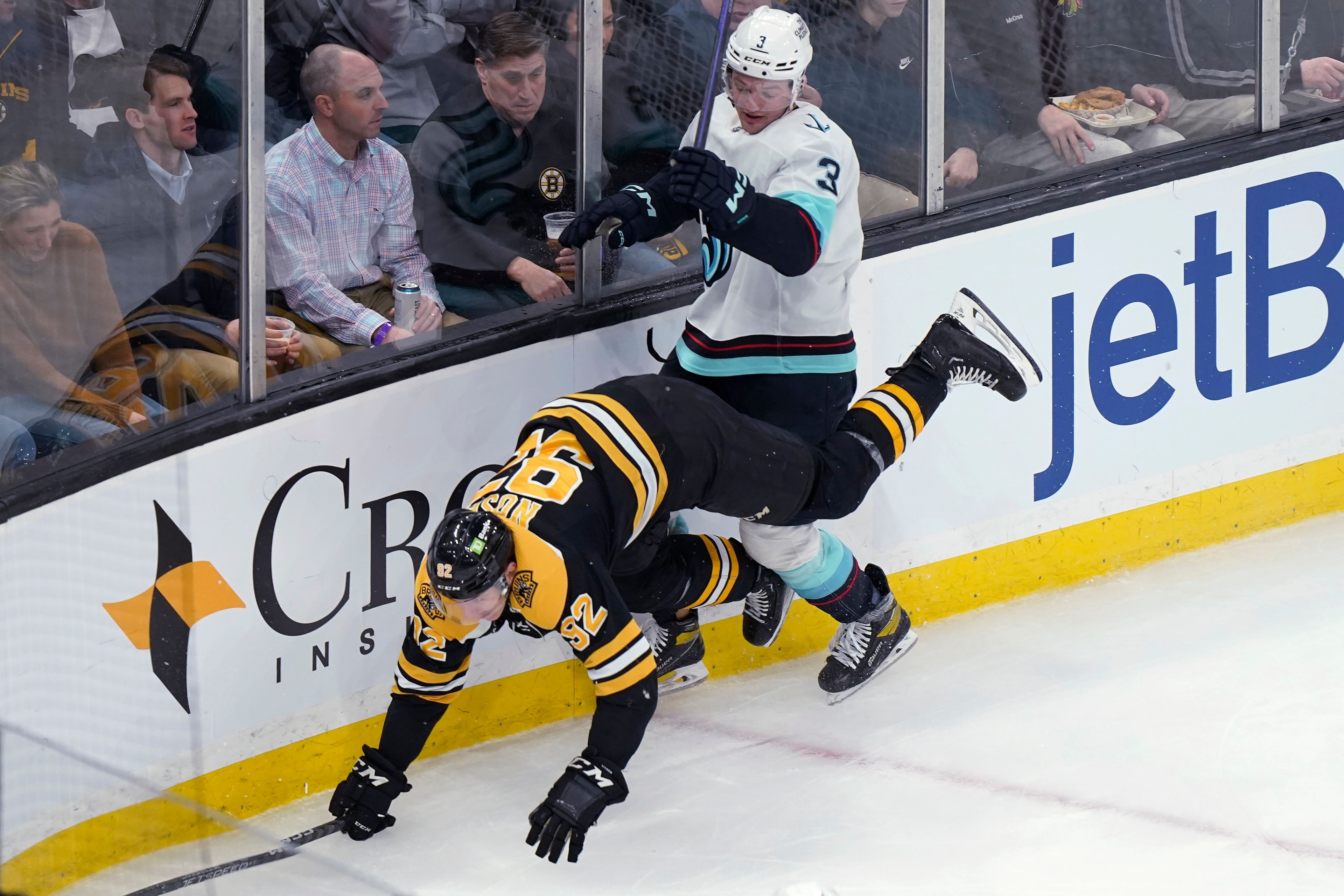 Boston Bruins left wing Tomas Nosek (92) falls after a collision with Seattle Kraken defenseman Will Borgen (3) during the second period of an NHL hockey game, Thursday, Jan. 12, 2023, in Boston. (AP Photo/Steven Senne)