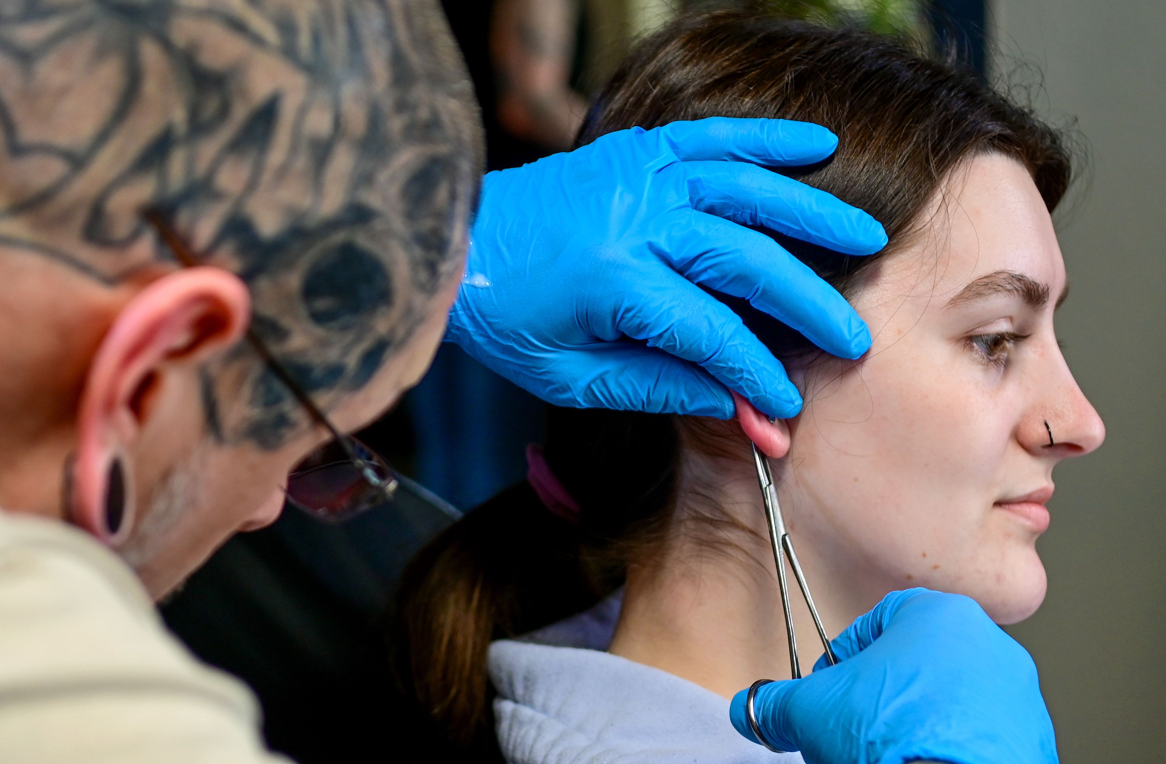 Blood Diamond Ink piercer Jon Slichter switches out Washington State University student Harley Sofie’s lobe jewelry to a longer length to aid with healing at the new piercing studio space next door to the tattoo shop Wednesday, April 17, in Pullman.