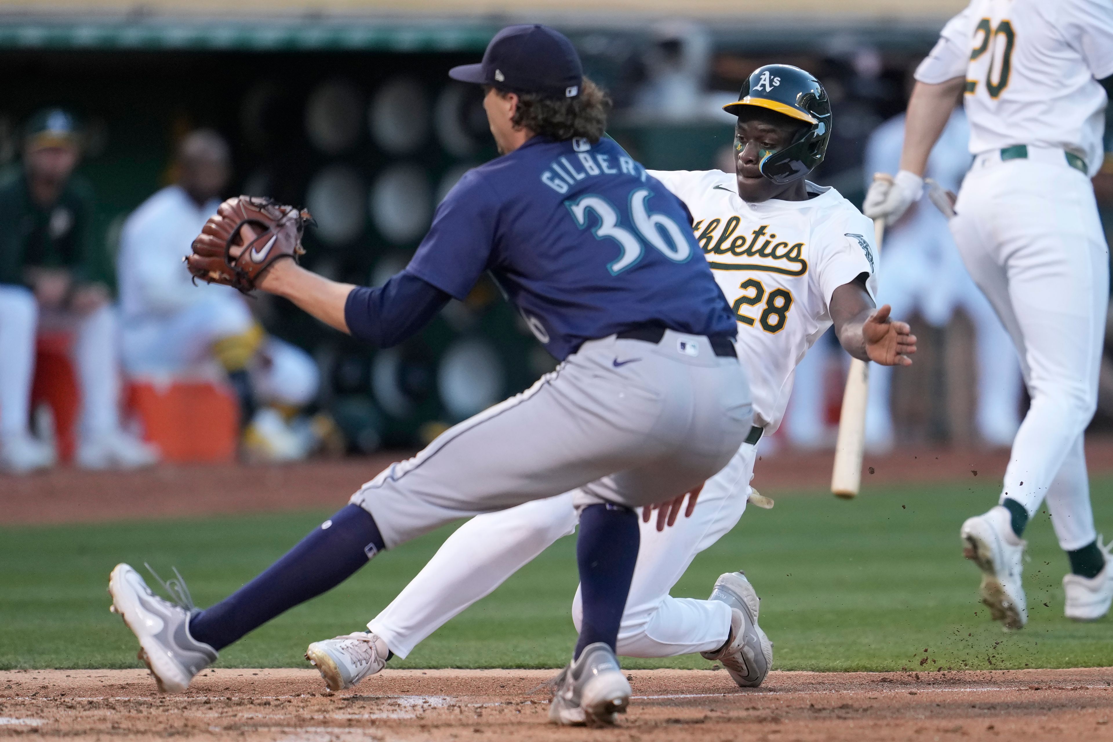 Oakland Athletics' Daz Cameron (28) slides home to score against Seattle Mariners pitcher Logan Gilbert (36) during the fifth inning of a baseball game in Oakland, Calif., Wednesday, June 5, 2024. (AP Photo/Jeff Chiu)