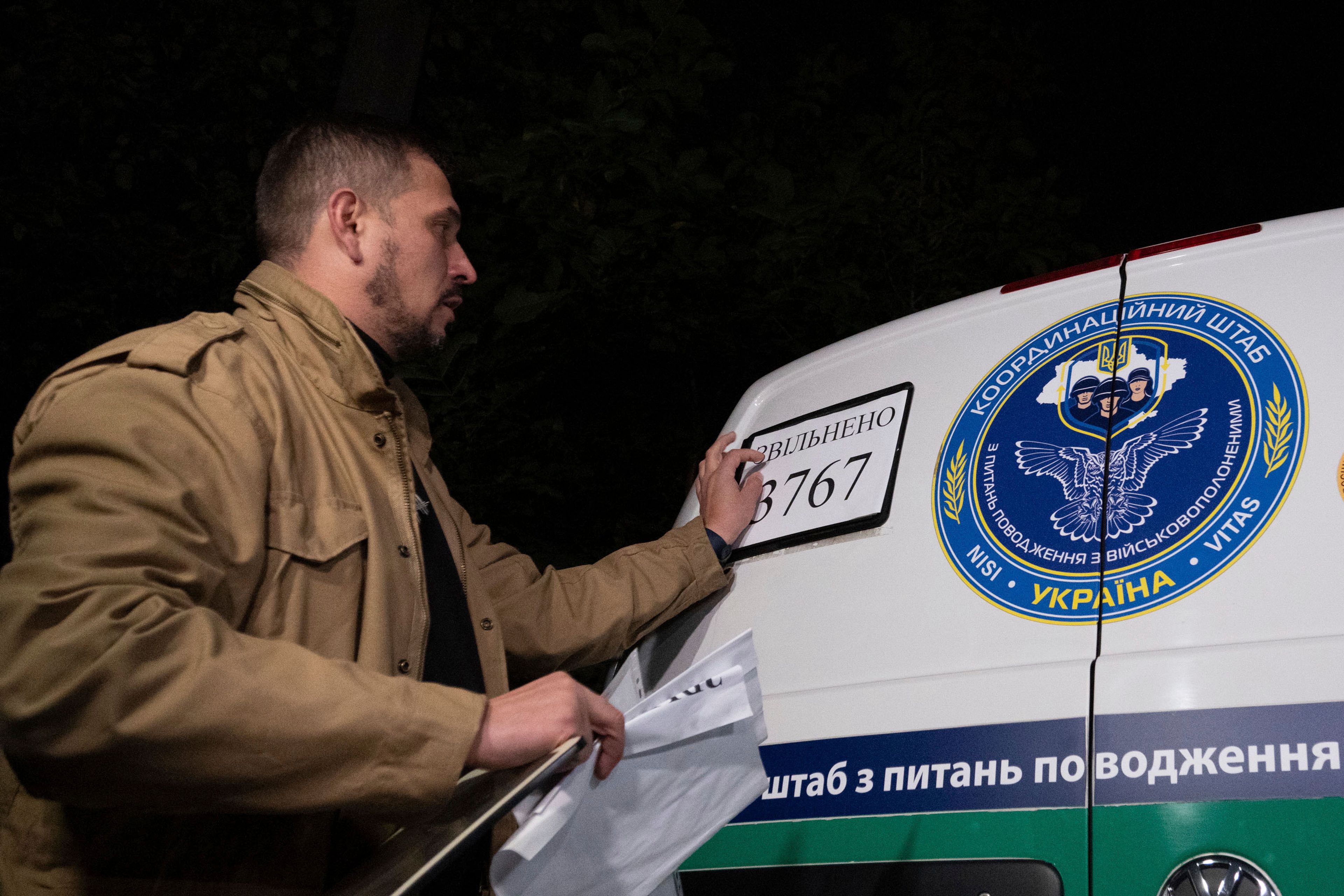 In this photo provided by the Press Service of the President of Ukraine on Oct. 19, 2024, a Ukrainian serviceman changes a plate showing the total sum of 3,767 of POWs and civilians returned after some of them have returned from captivity during a POWs exchange in an undisclosed location, Ukraine. (Press Service of the President of Ukraine via AP)