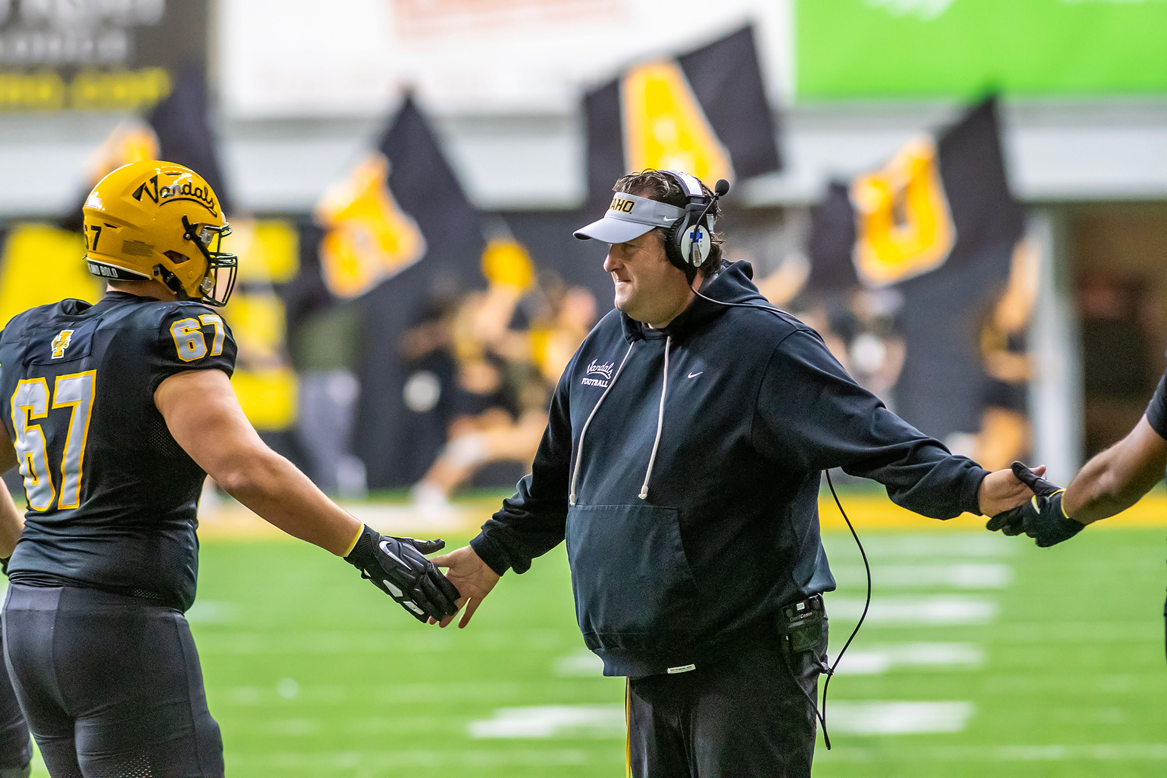 Idaho head coach Jason Eck slaps hands with players after a Vandals touchdown against Eastern Washington during a Big Sky game Saturday at the Kibbie Dome in Moscow. 