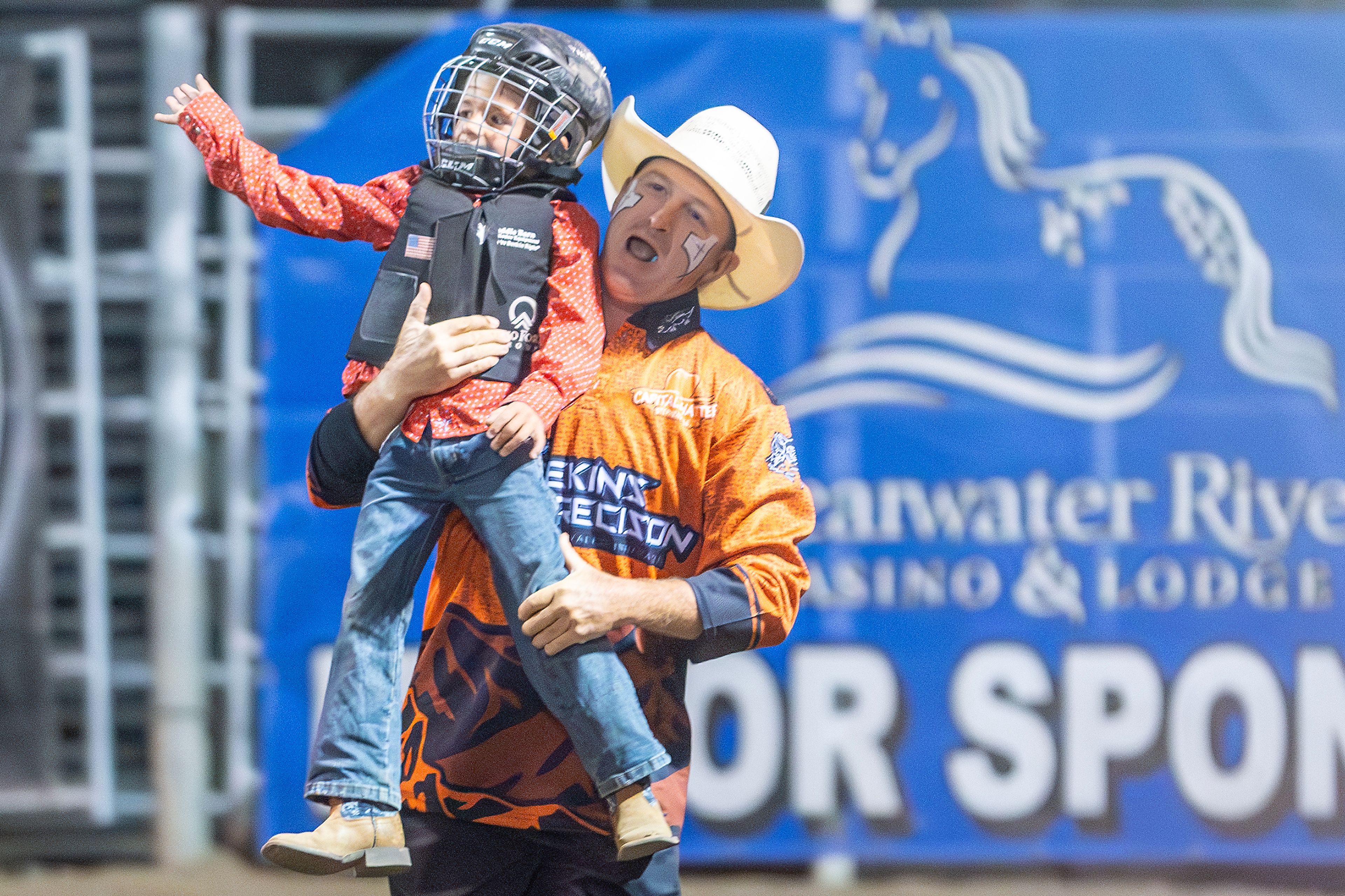 Cedar Swanson, of Clarkston, is lifted up by bull fighter Clay Heger, of Asotin, after a victory in the wool riding competition on day 2 of the Lewiston Roundup.