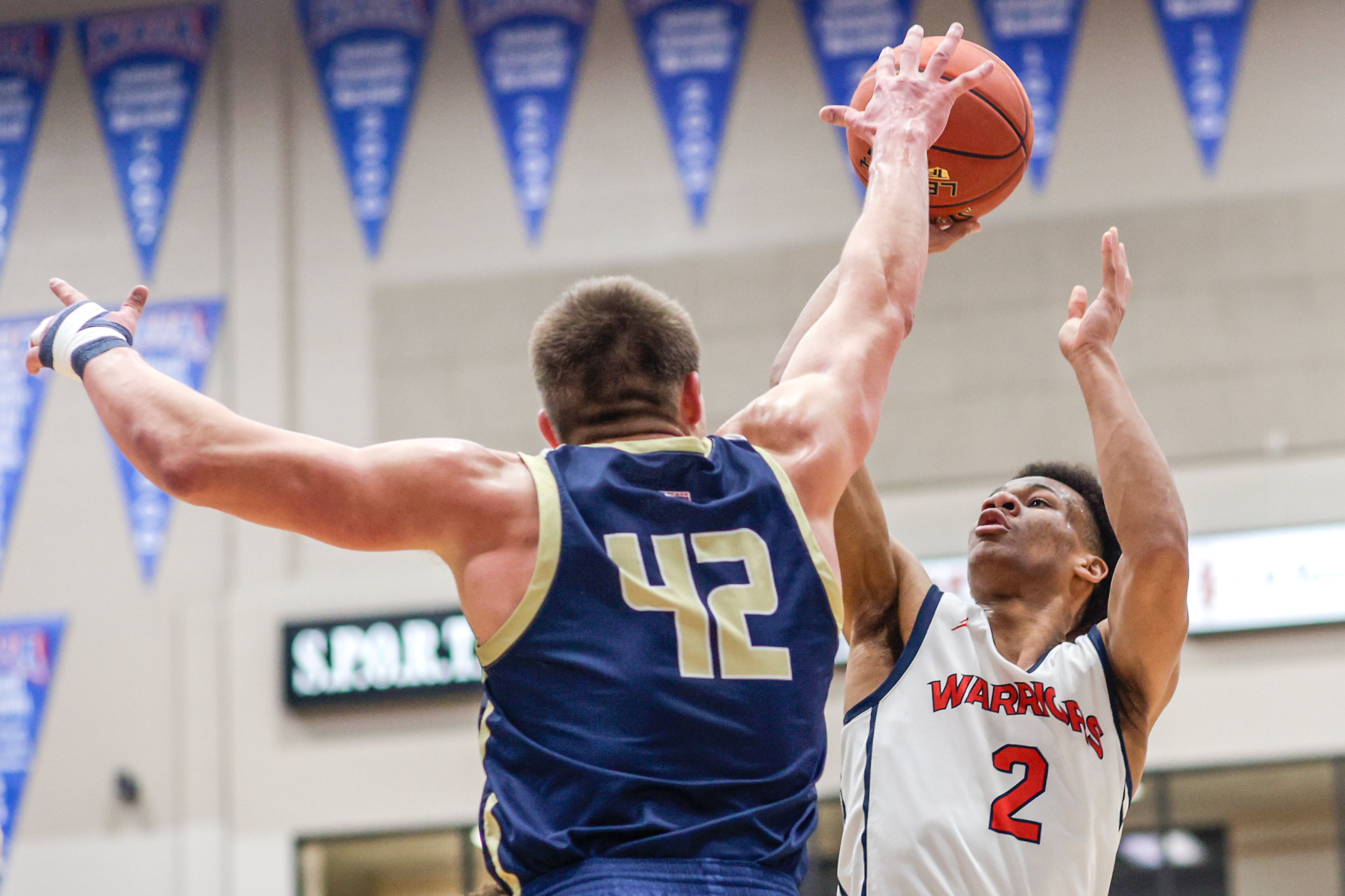 Lewis-Clark State guard Davian Brown, right, shoots as Eastern Oregon guard Justin Jeske defends during a Cascade Conference game Friday at Lewis-Clark State College.