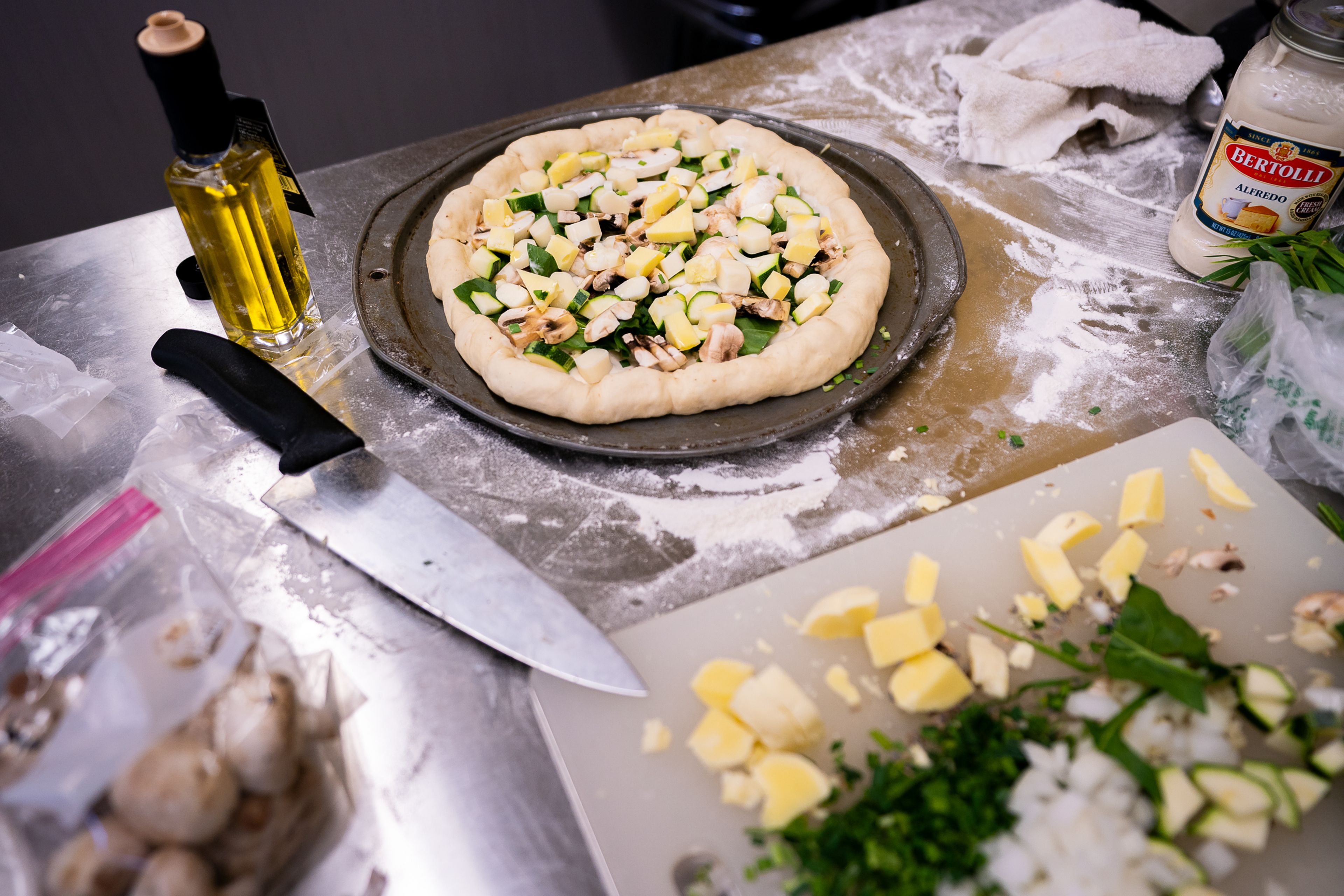 A white sauce veggie pizza made by Memory H., of Kellogg, waits to be placed inside an oven during the final day of the 2023 Pizza-ology Camp on Wednesday at the Carmelita Spencer Food Laboratory in Moscow.