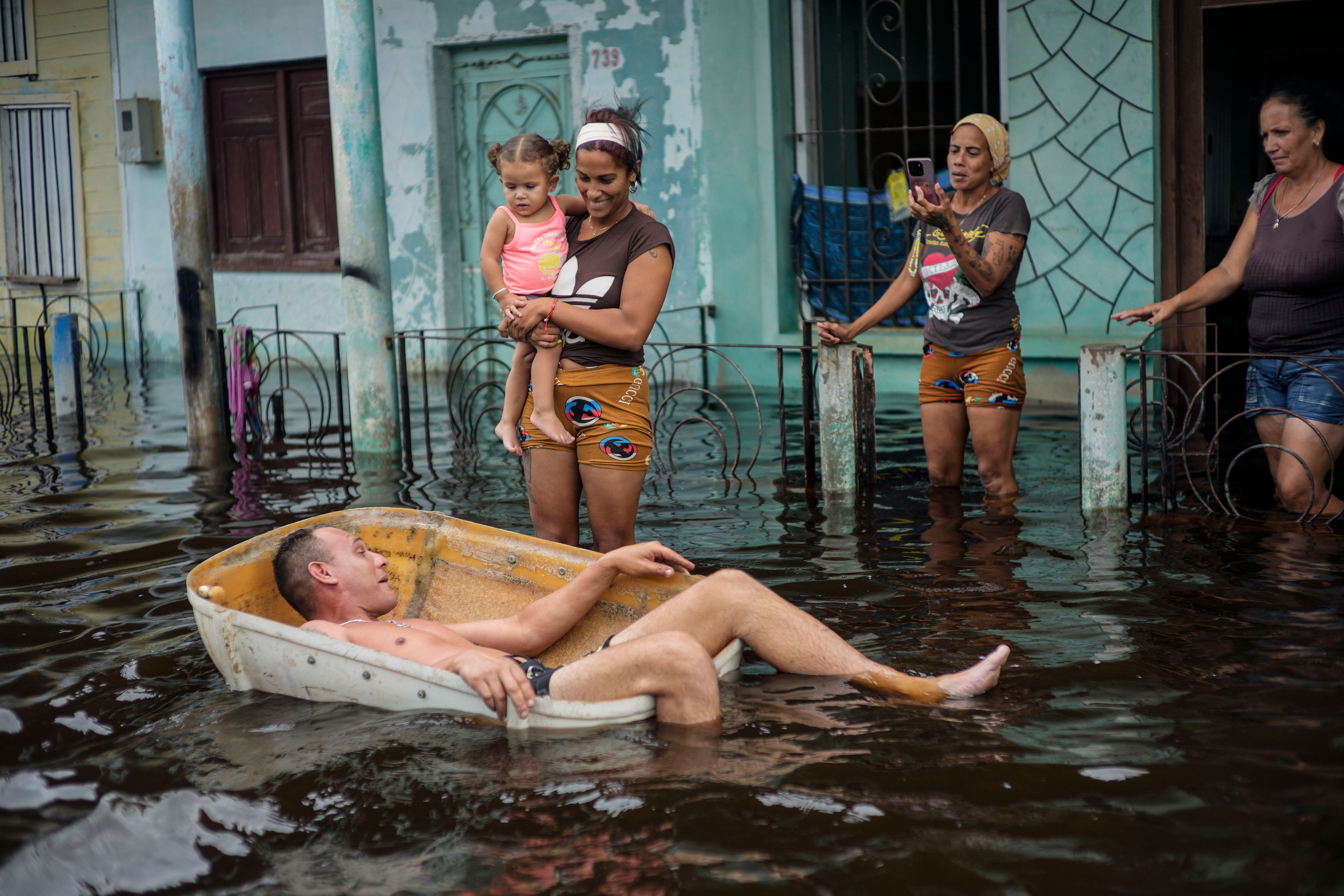 A man floats in a container on a street flooded by the passing of Hurricane Helene, in Batabano, Mayabeque province, Cuba, Thursday, Sept. 26, 2024. (AP Photo/Ramon Espinosa)