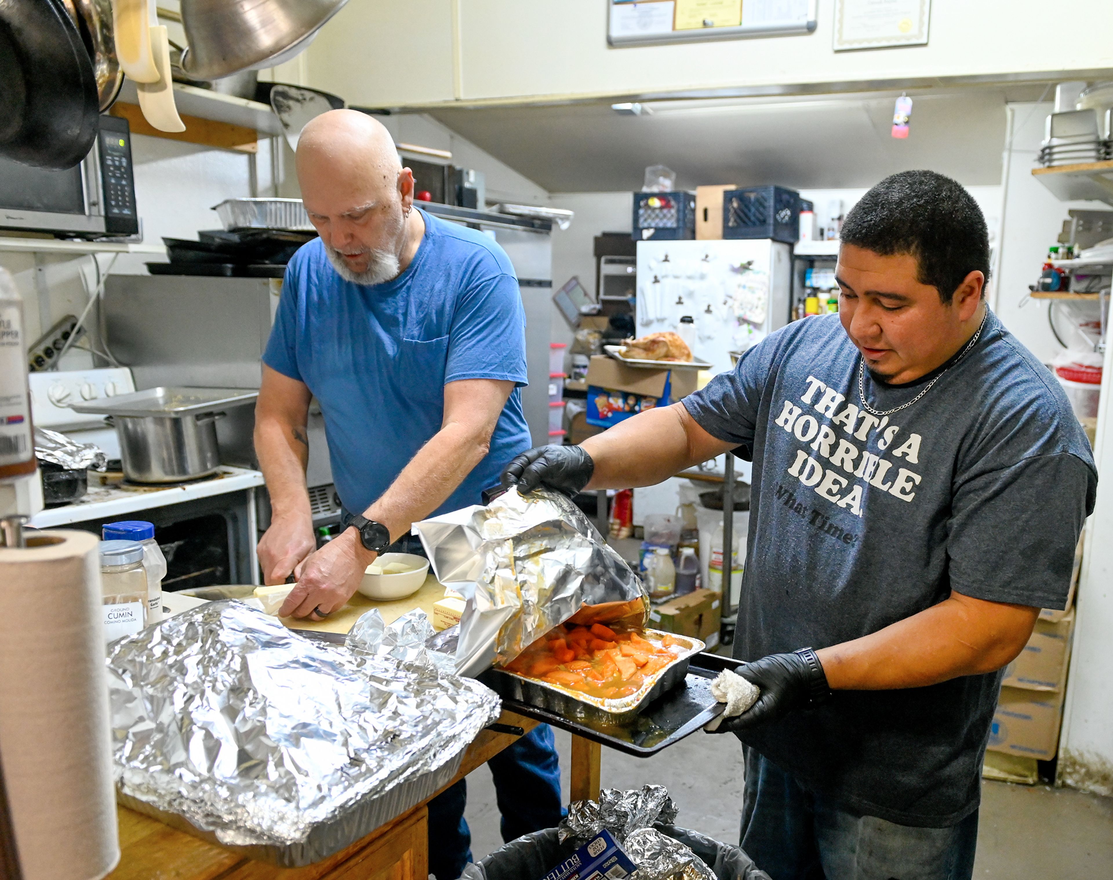 Waha Grill co-owner Adam Hayward, left, and general manager and executive chef David Reyes prepare food in the kitchen Thursday during the restaurant’s annual free Thanksgiving meal on the outskirts of Lewiston.