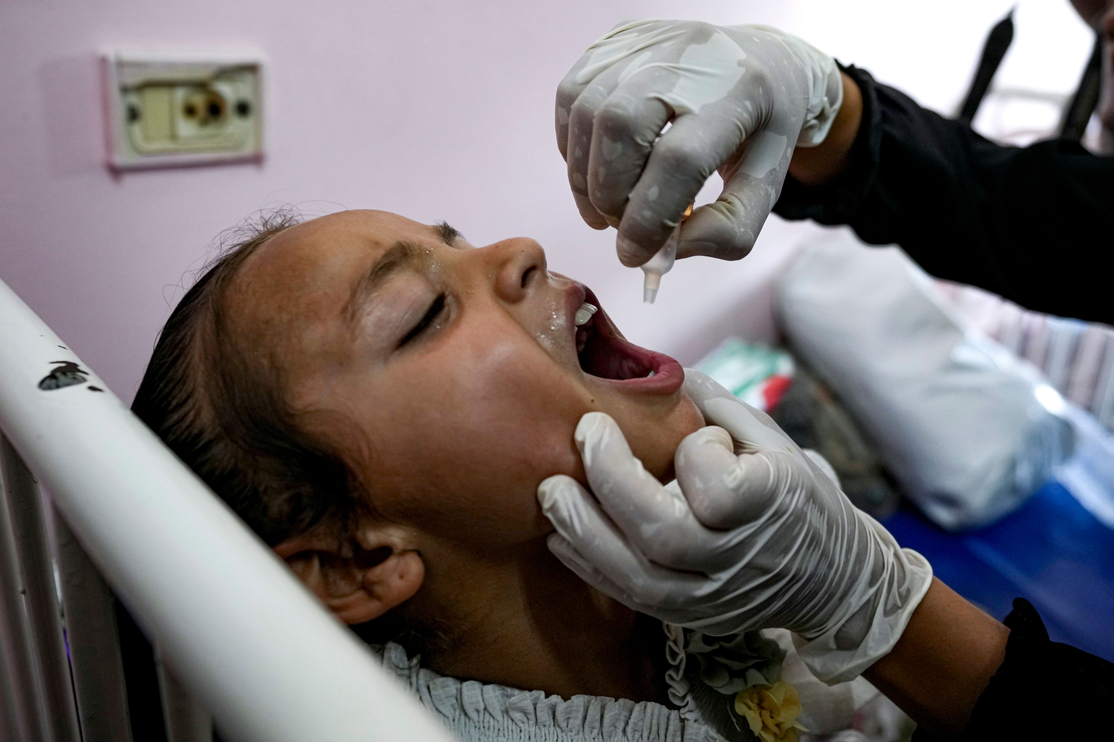 A health worker administers a polio vaccine to a child at a hospital in Khan Younis, Saturday, Aug. 31, 2024. (AP Photo/Abdel Kareem Hana)