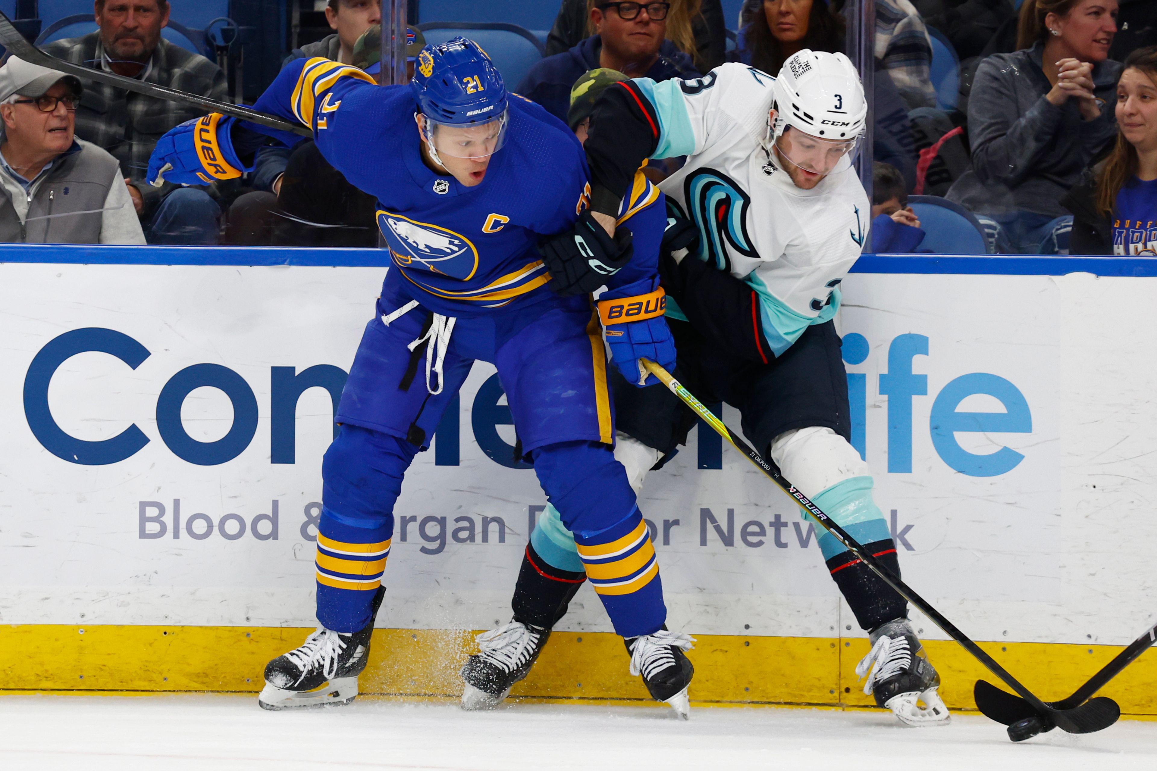 Buffalo Sabres right wing Kyle Okposo (21) and Seattle Kraken defenseman Will Borgen (3) battle for the puck during the first period of an NHL hockey game, Tuesday, Jan. 10, 2023, in Buffalo, N.Y. (AP Photo/Jeffrey T. Barnes)