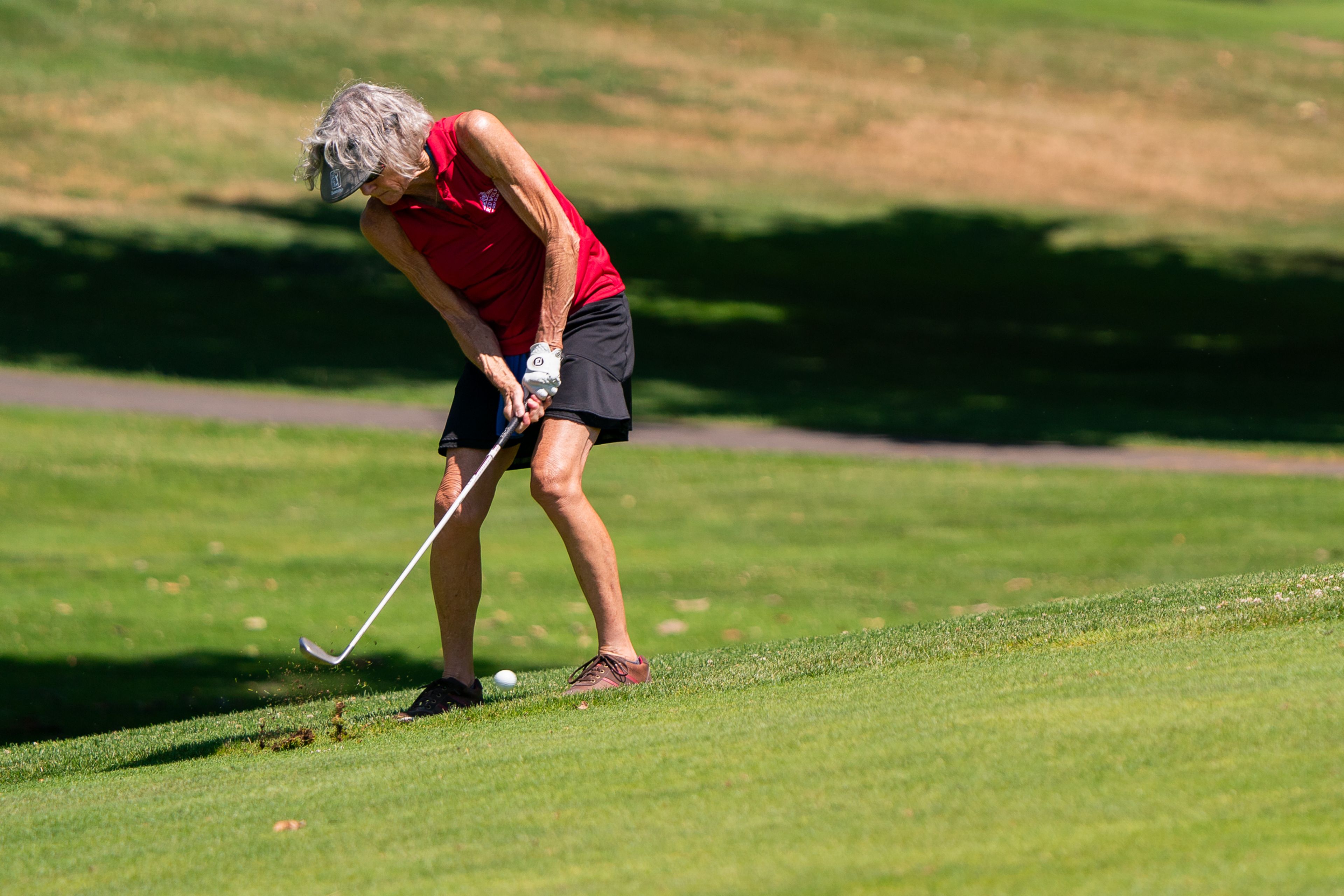 Margaret Hair hits her ball up a hill during the Tribune Cup women’s golf tournament on Tuesday at Red Wolf Golf Club in Clarkston. Hair represented Red Wolf Golf Club during the tournament.