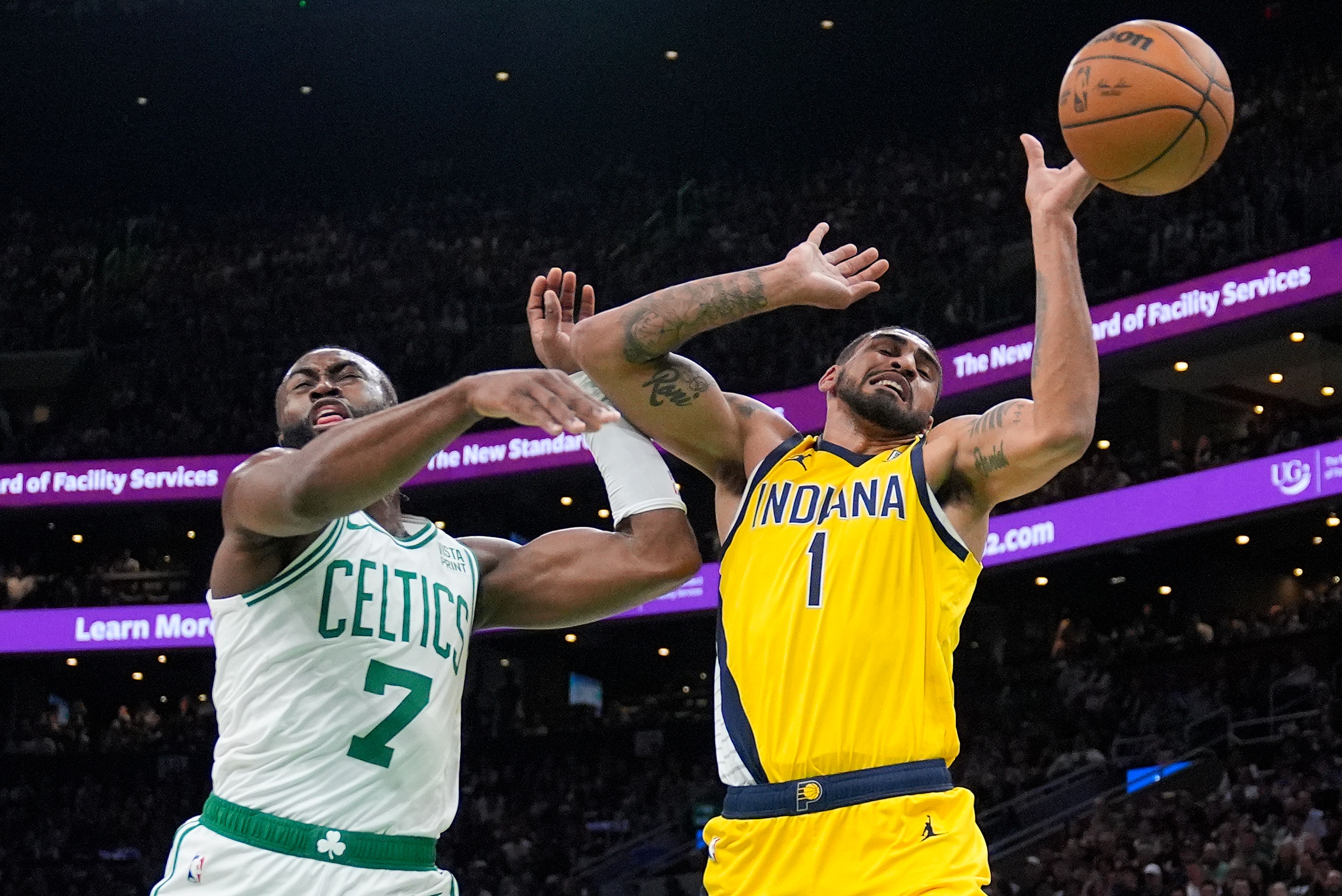 Celtics guard Jaylen Brown, left, and Pacers forward Obi Toppin, right, battle for a rebound during Game 1 of the Eastern Conference finals Tuesday in Boston.