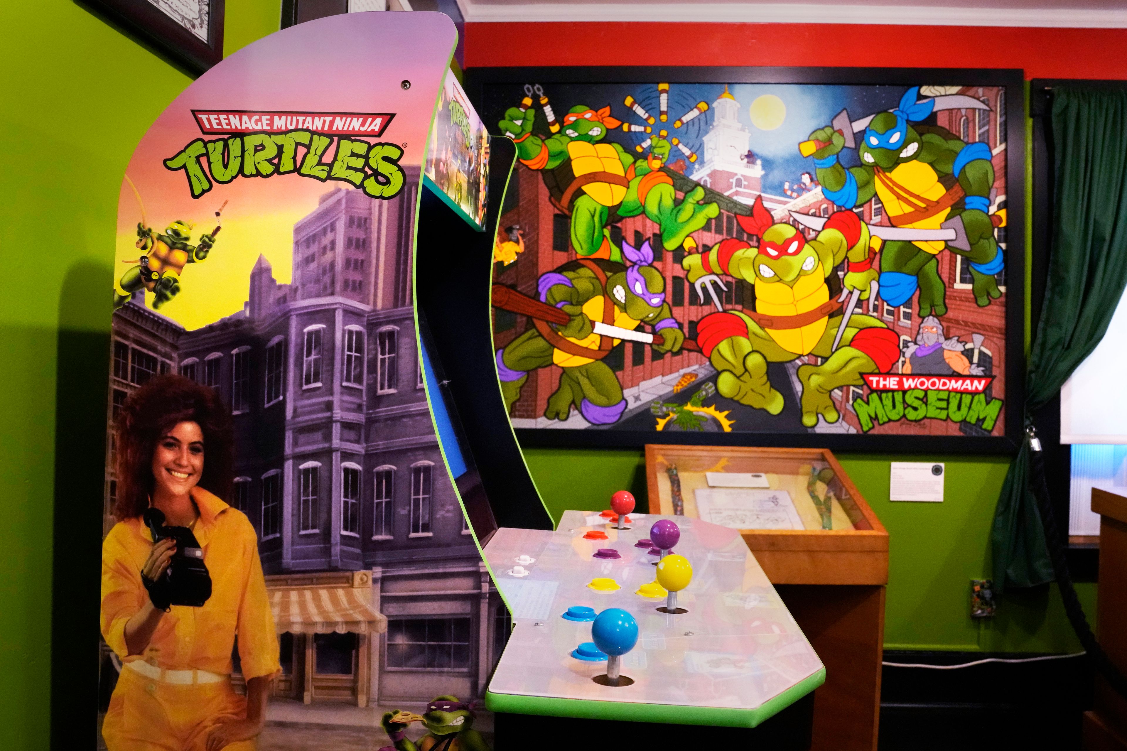 A Teenage Mutant Ninja Turtle arcade video game and painting by a local artist are displayed as part of the permanent collection at the Woodman Museum, Thursday, Sept. 5, 2024, in Dover, N.H.