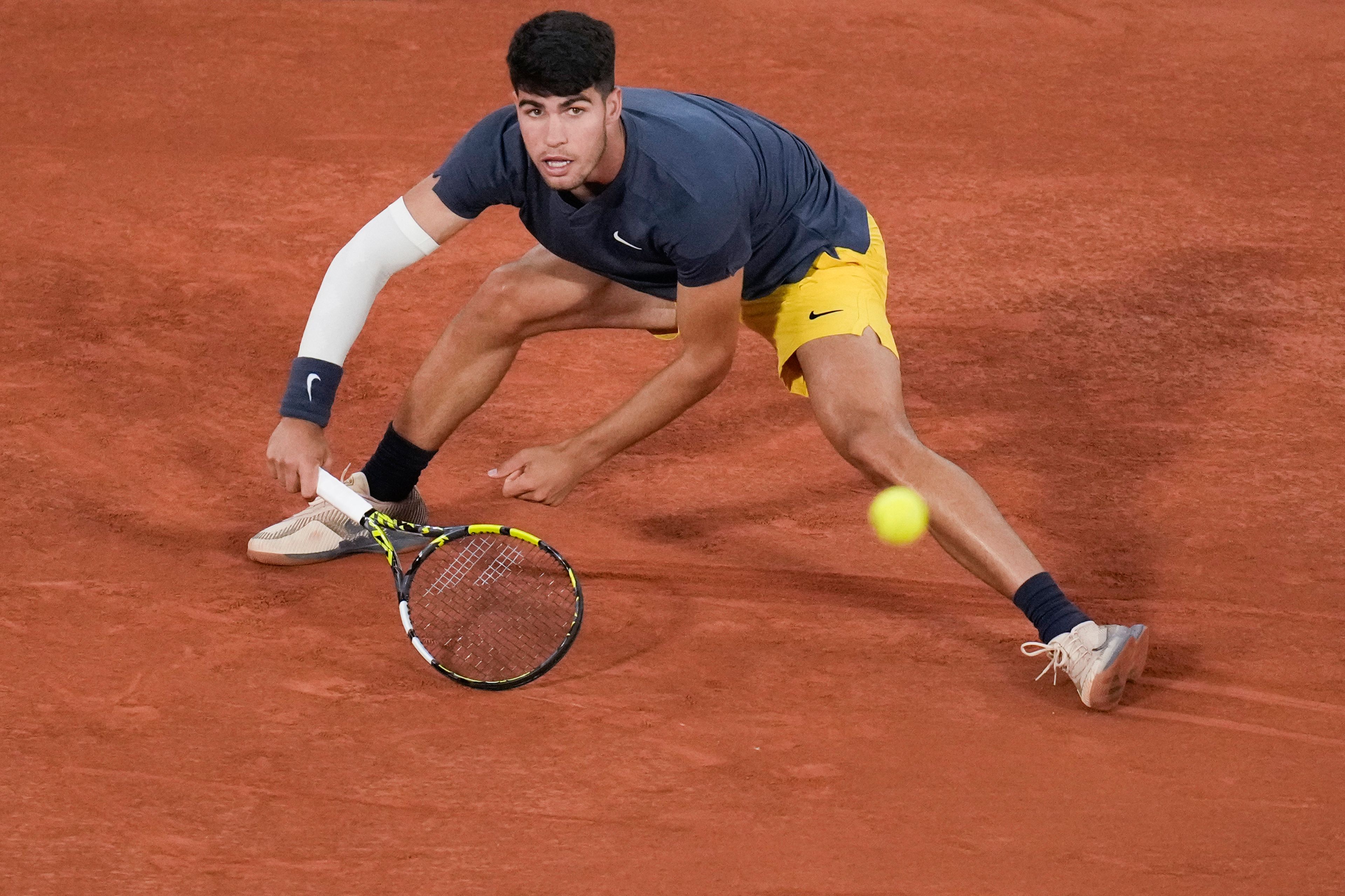 Spain's Carlos Alcaraz slides to play shot against Jeffrey John Wolf of the U.S. during their first round match of the French Open tennis tournament at the Roland Garros stadium in Paris, Sunday, May 26, 2024.