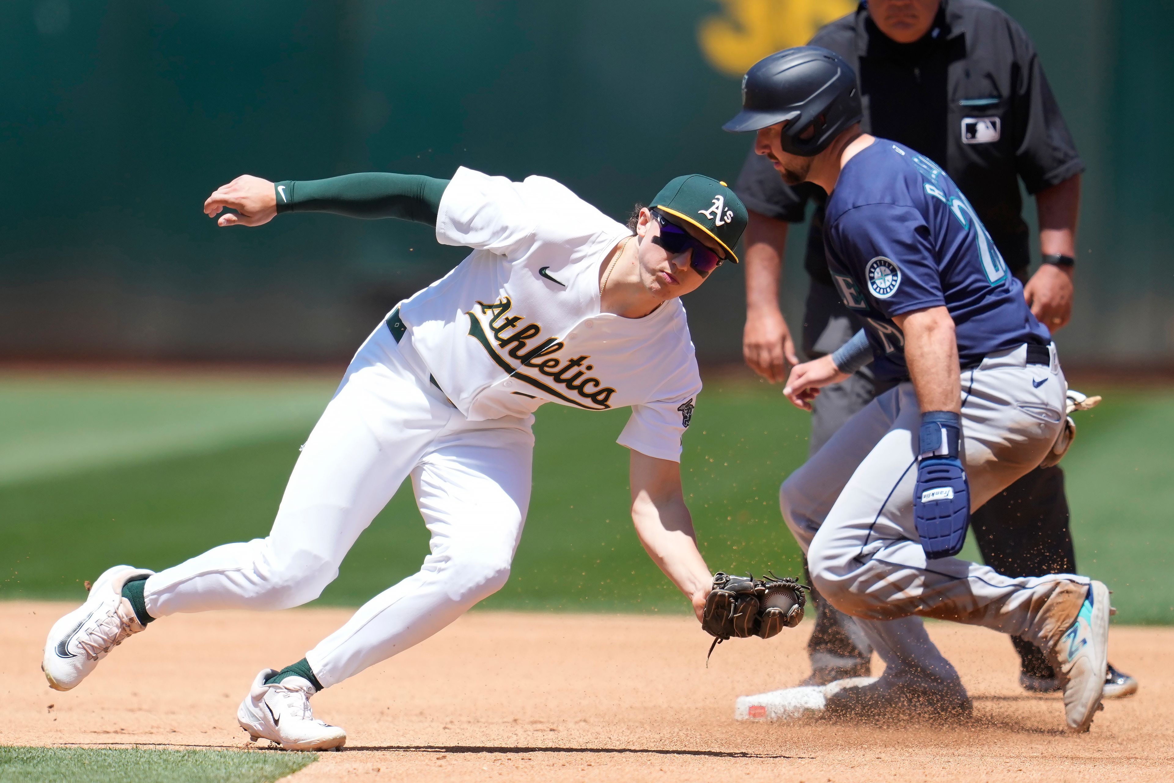 Seattle Mariners catcher Cal Raleigh, right, steals second base next to Oakland Athletics second baseman Zack Gelof during the fourth inning of a baseball game in Oakland, Calif., Thursday, June 6, 2024. (AP Photo/Jeff Chiu)