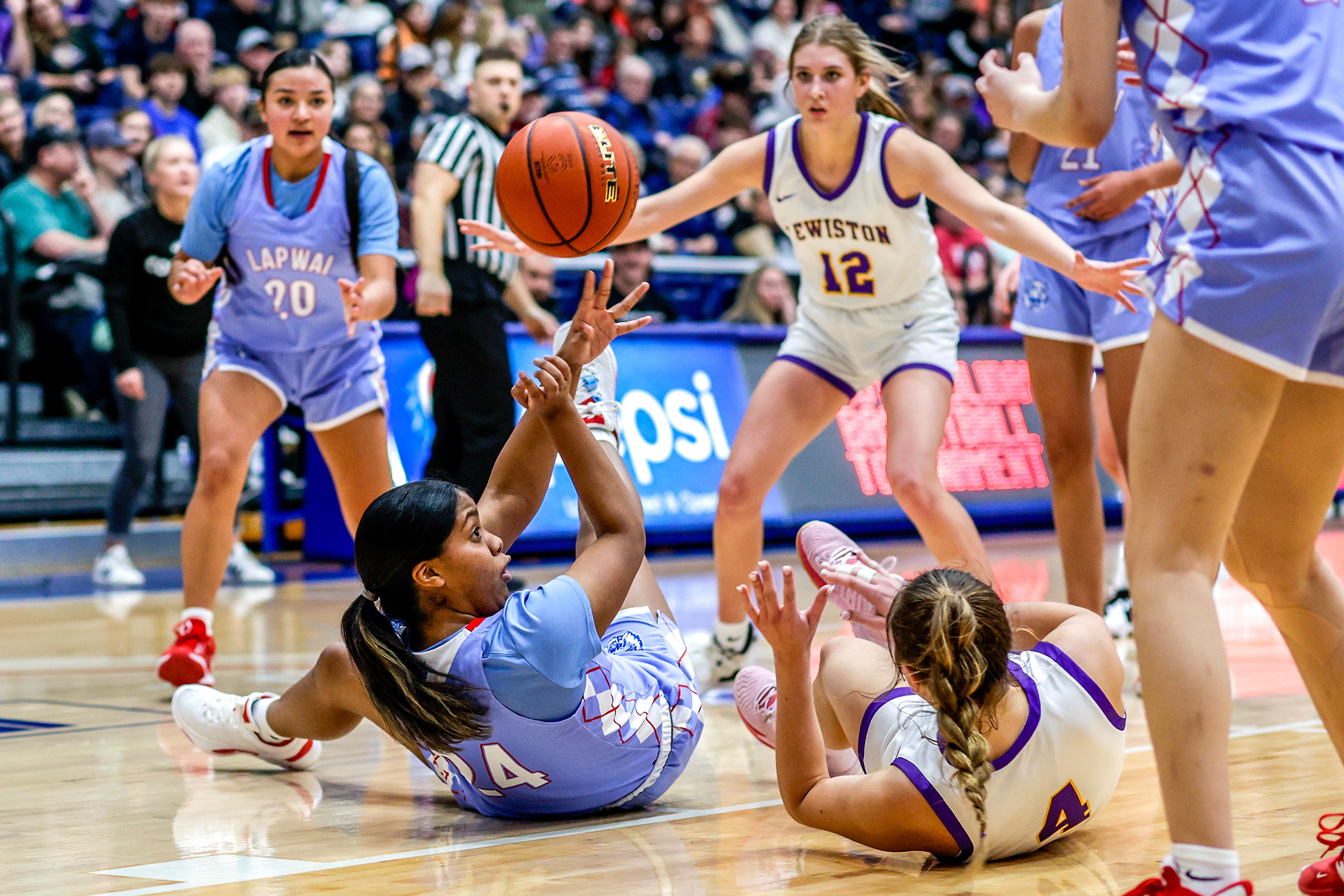 Lapwai power forward Qubilah Mitchell, on ground, passes the ball to a teammate during the Avista Holiday Tournament on Wednesday against Lewiston.