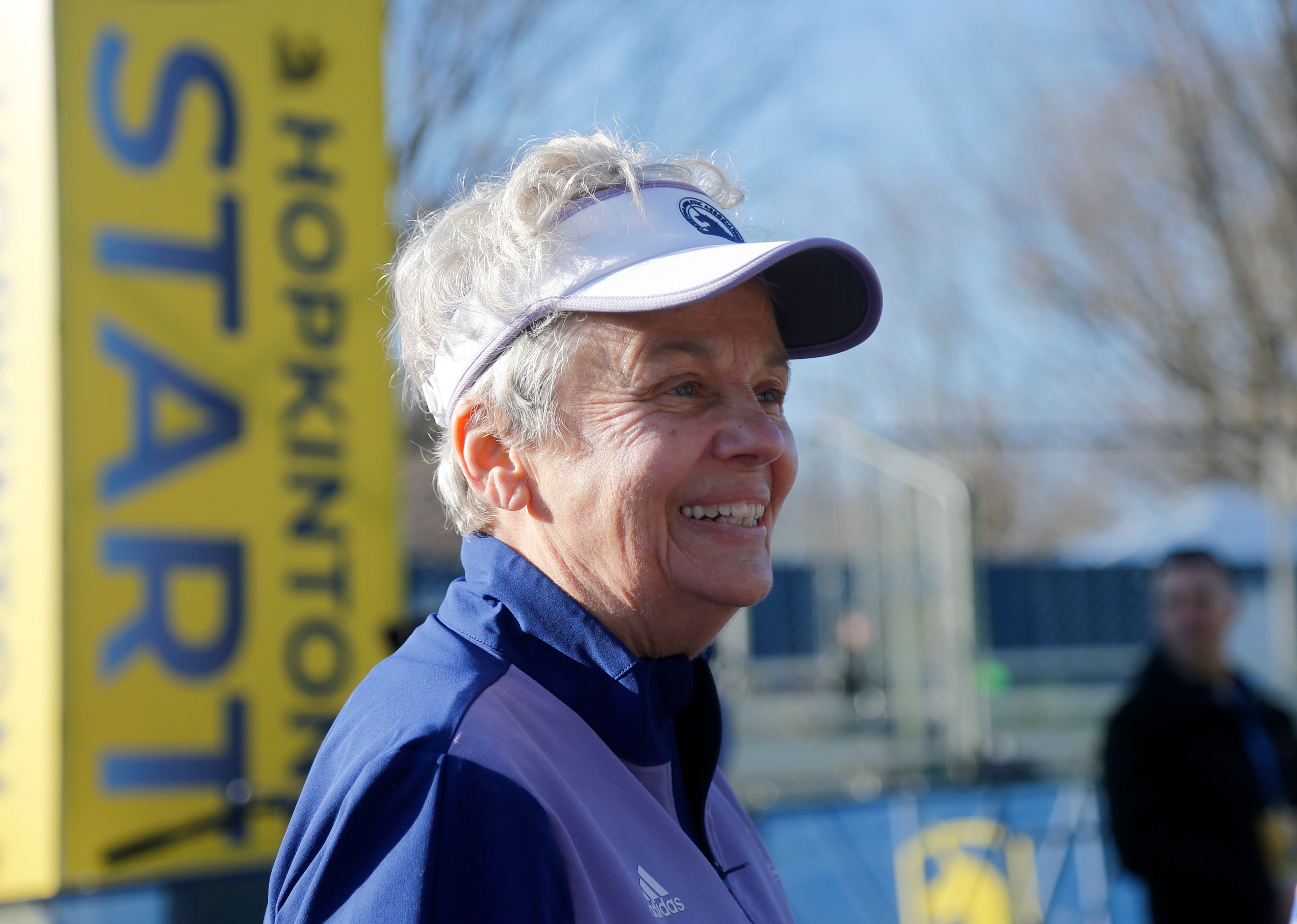 Val Rogosheske, who raced in the inaugural women's division in 1972, stands at the starting line of the 126th Boston Marathon, Monday, April 18, 2022, in Hopkinton, Mass. Rogosheske will run the race with her two daughters 50 years after running her first Boston marathon. (AP Photo/Mary Schwalm)