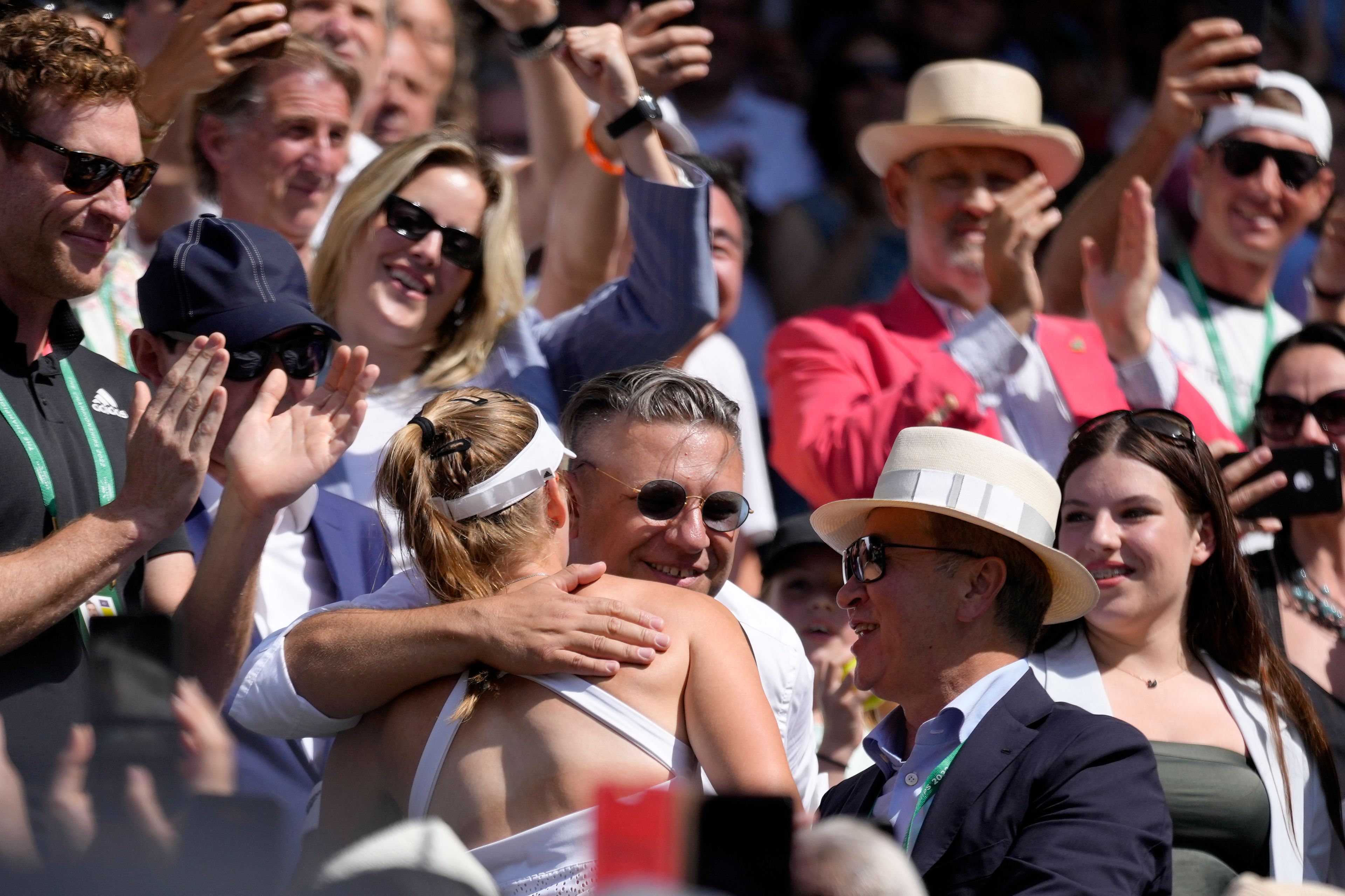 Kazakhstan's Elena Rybakina is embraced by family, friends and coaches in the players box as she celebrates after beating Tunisia's Ons Jabeur to win the final of the women's singles on day thirteen of the Wimbledon tennis championships in London, Saturday, July 9, 2022. (AP Photo/Kirsty Wigglesworth)