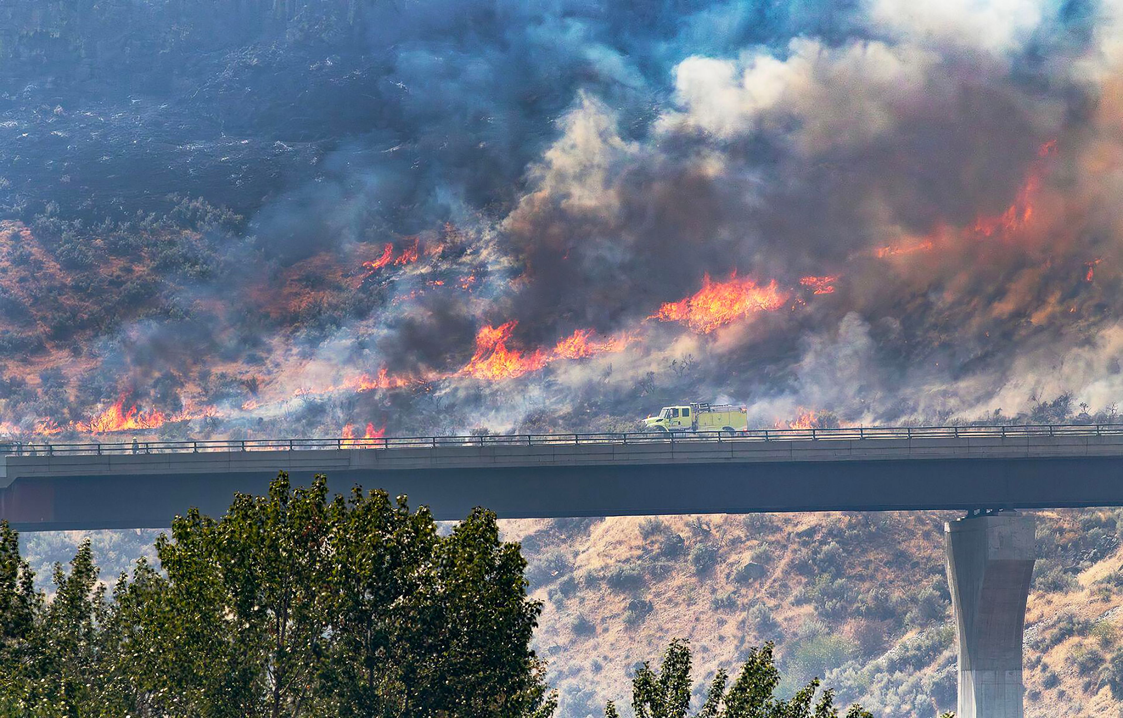 Flames from the Plex fire climb a hillside Thursday along Idaho Highway 21 above the Boise River.