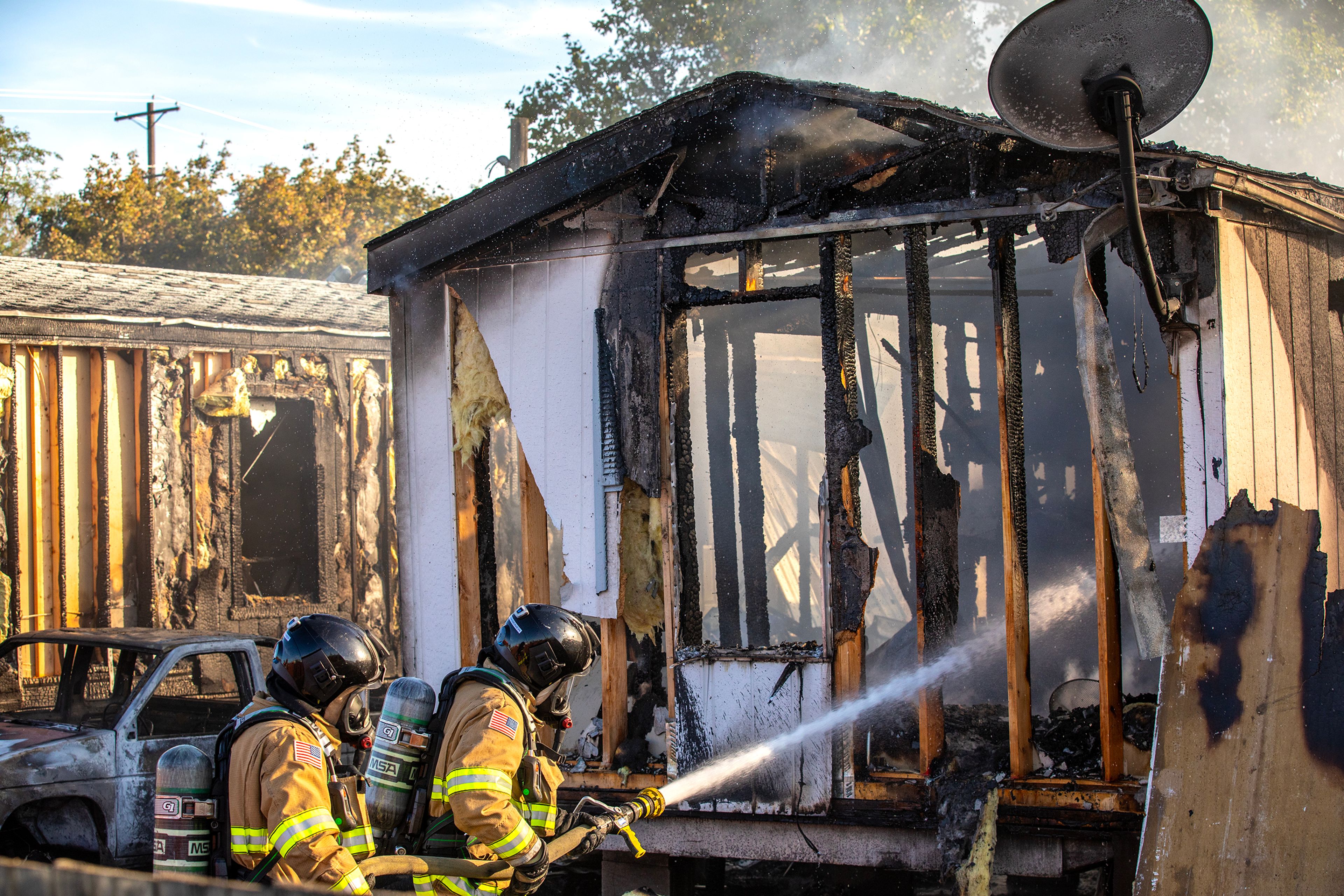 Firefighters spray down a structure fire at a mobile home Thursday off 13th Street in Clarkston.