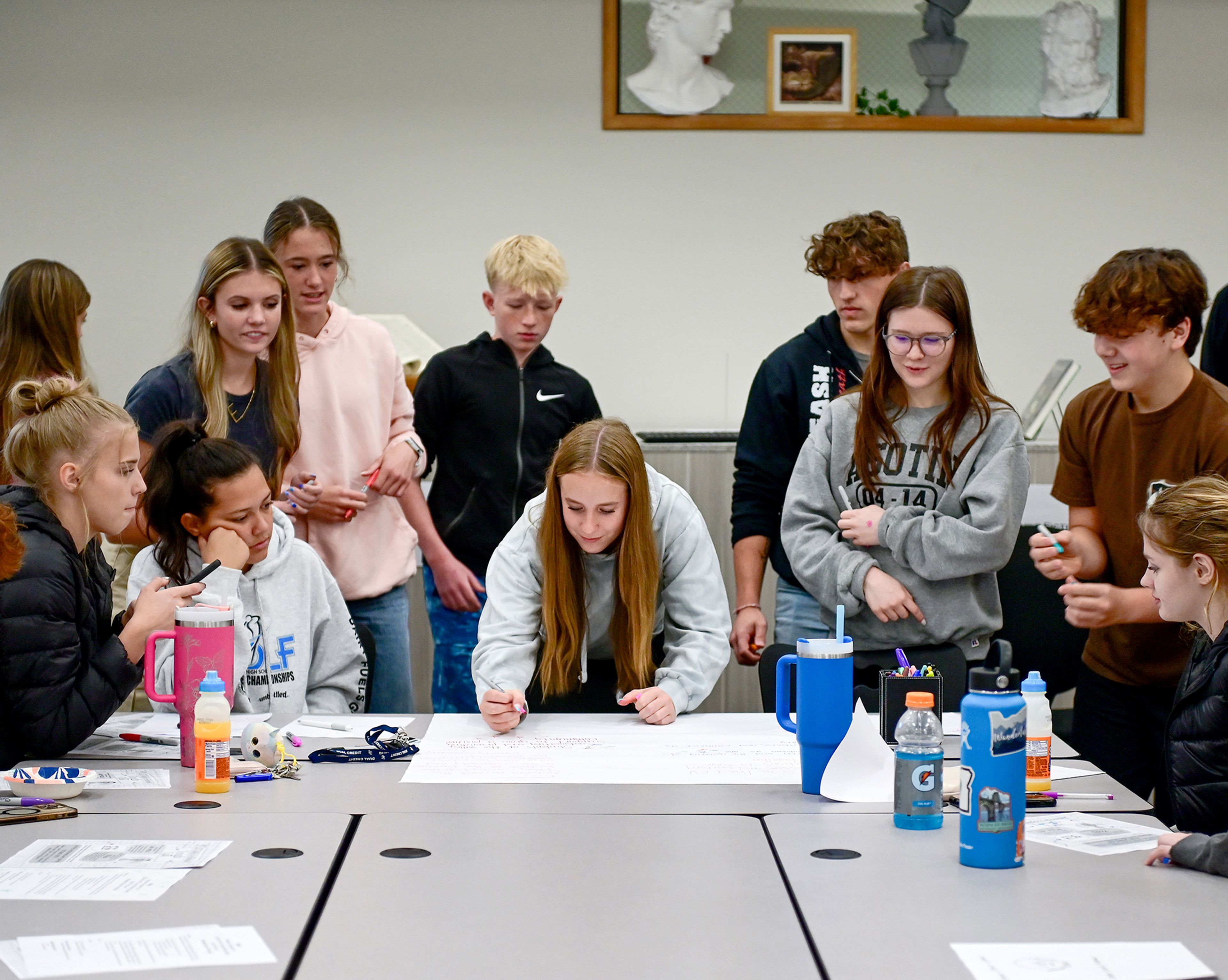 Members of the Students of the Valley Advocacy group gather around a poster to vote on different ideas for a mission statement during a meeting Monday at Asotin High School.,