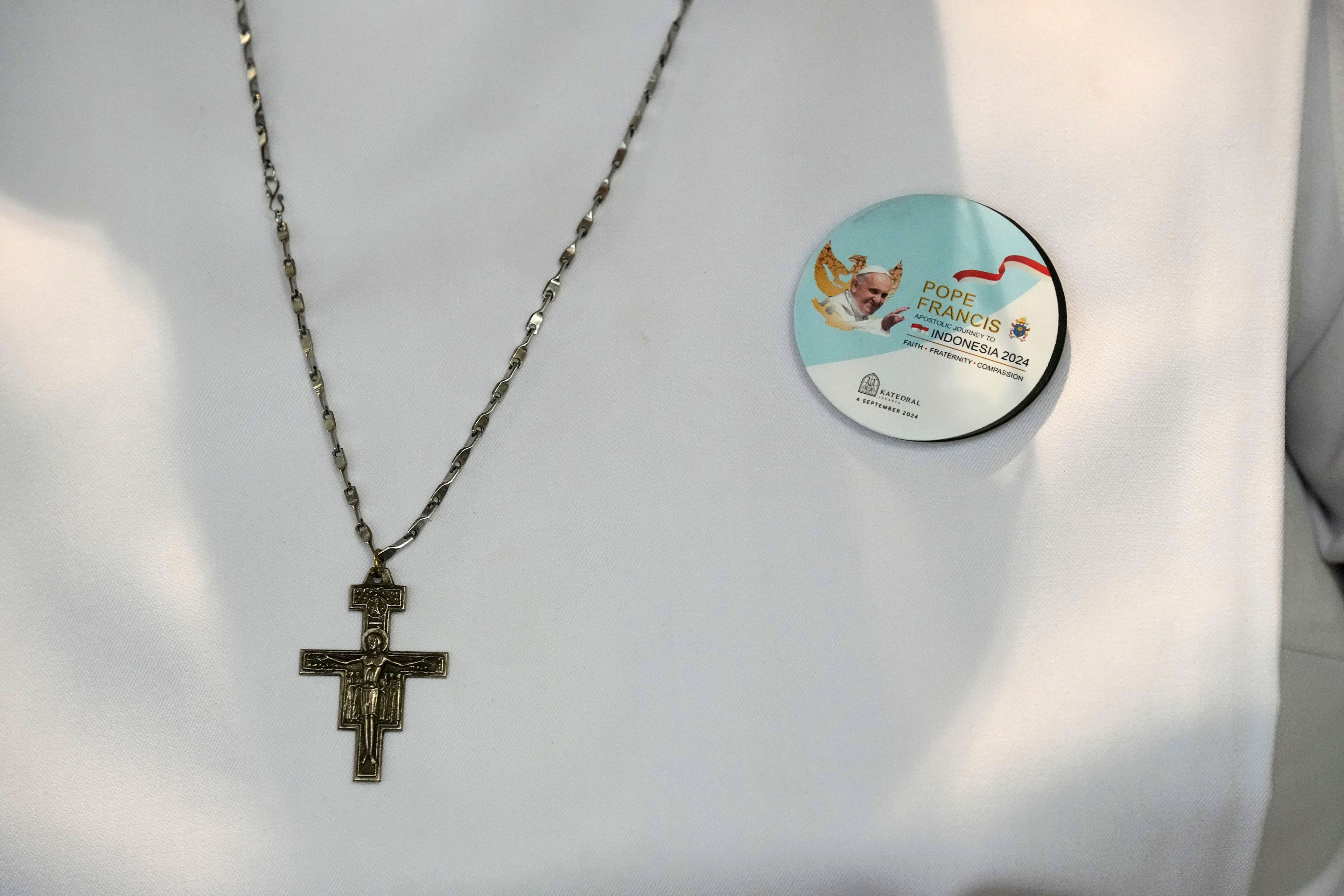 A nun wears a crucifix and a badge showing Pope Francis as she waits for the Pope's arrival in the Cathedral of Our Lady of the Assumption, the capital's main Catholic cathedral, in Jakarta, Indonesia, Wednesday, Sept. 4, 2024.