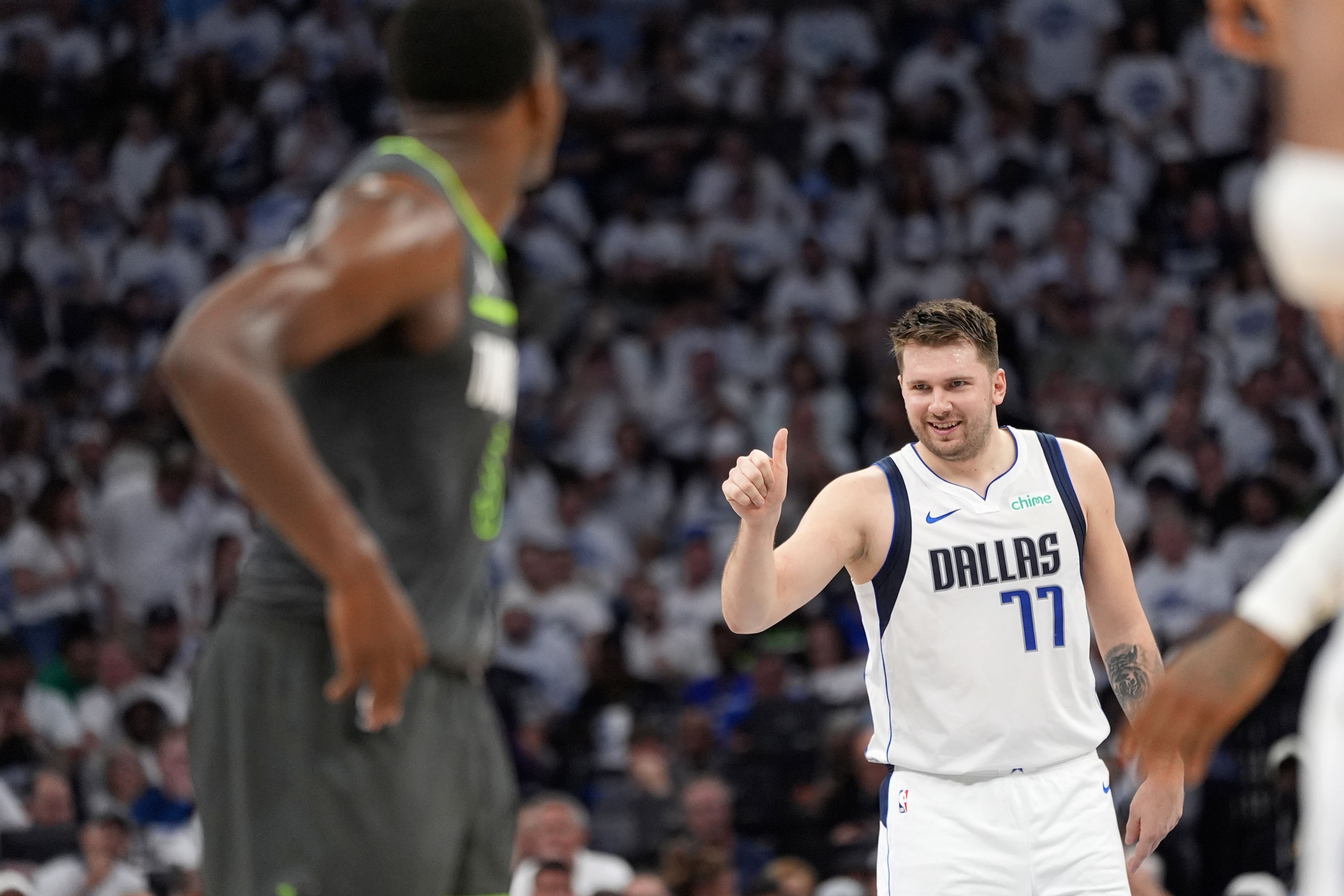 Mavericks guard Luka Doncic, right, celebrates his score as Timberwolves guard Anthony Edwards, left, looks on during the first half of Game 5 of the Western Conference finals in the NBA playoffs Thursday in Minneapolis.