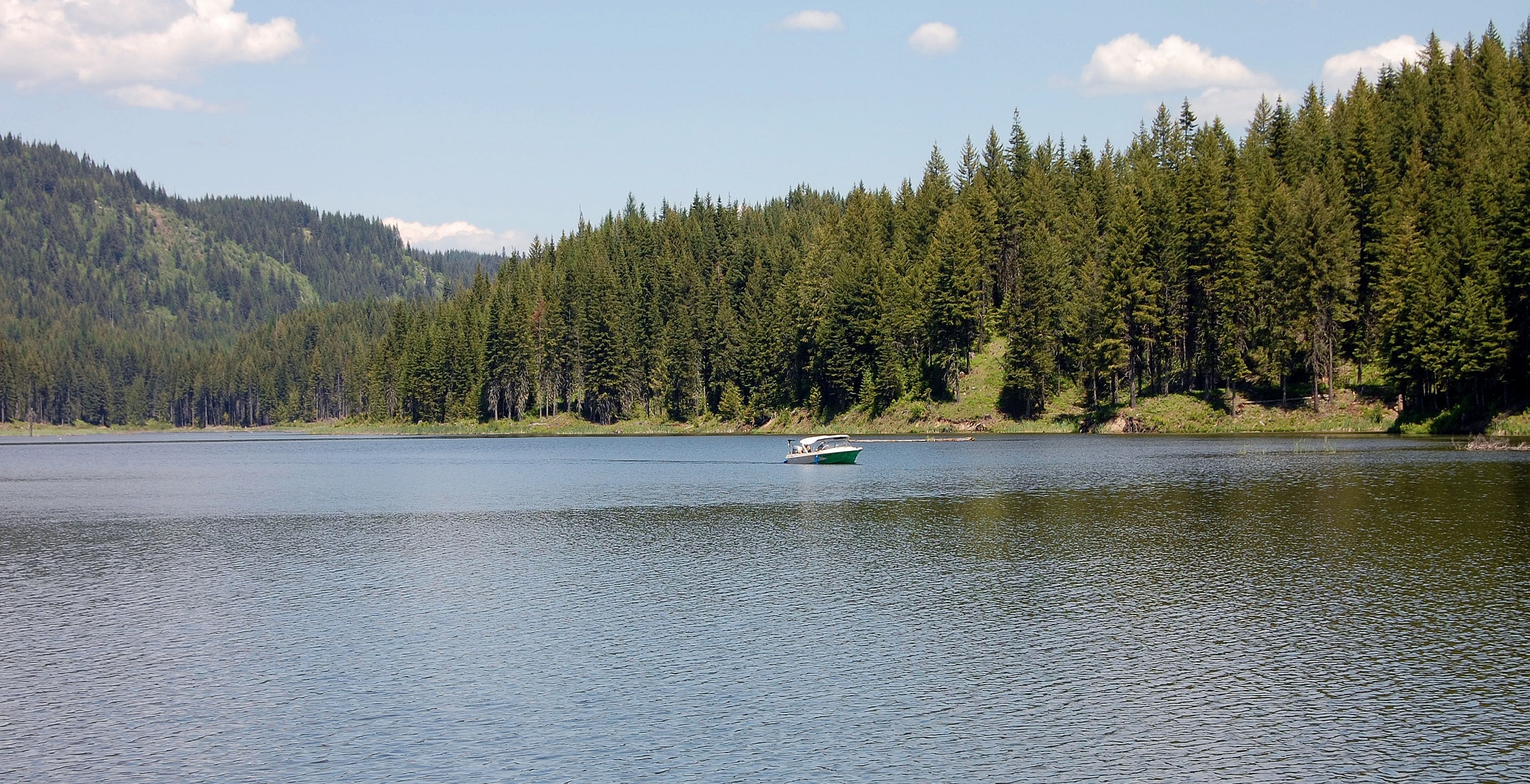 A boat slowly motors across Deer Creek Reservoir. The manmade body of water near Pierce was open in 2004 and is stocked with trout.