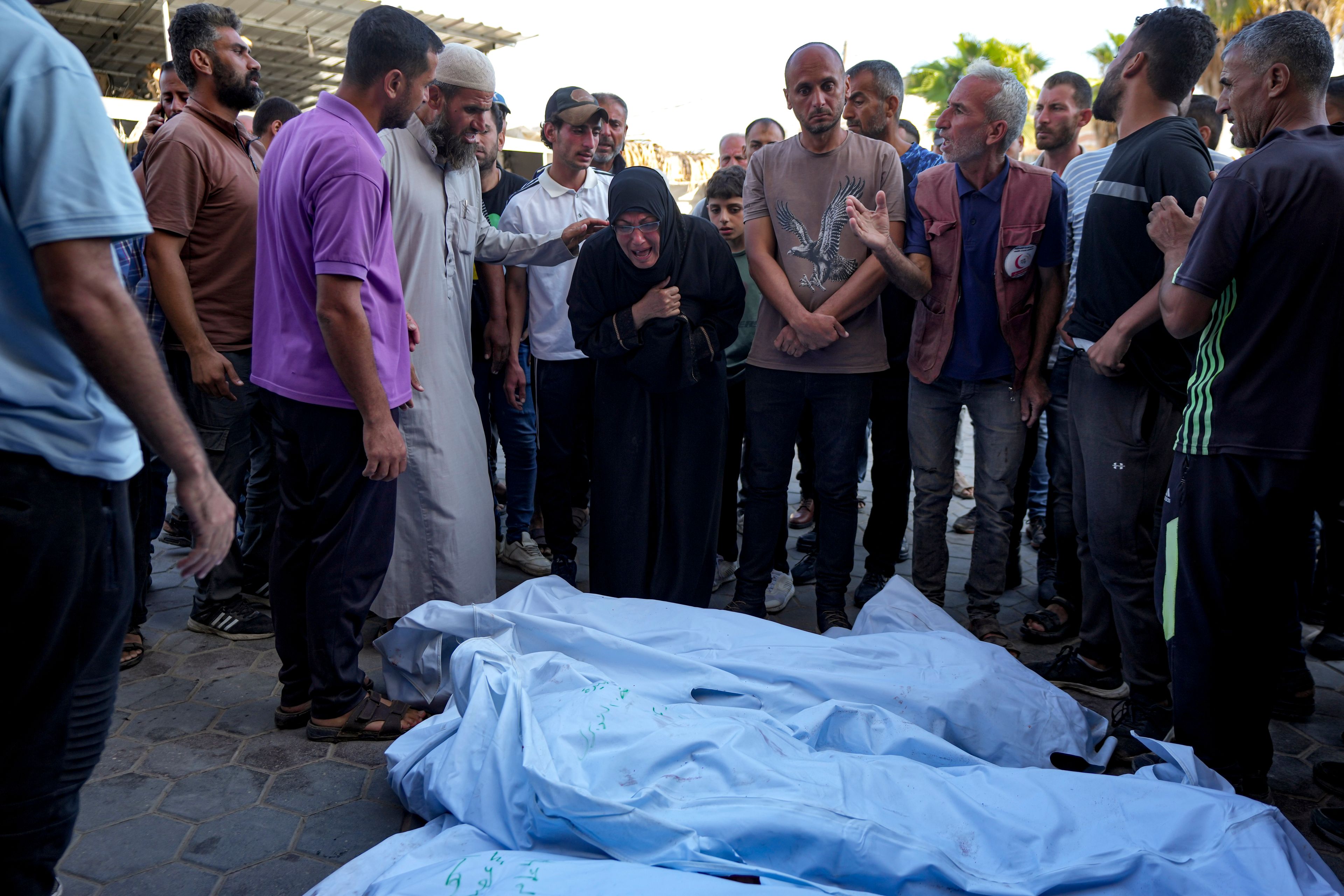 Palestinians mourn for relatives killed in the Israeli bombardment of the Gaza Strip at a hospital morgue in Deir al-Balah, Wednesday, Oct. 2, 2024. (AP Photo/Abdel Kareem Hana)