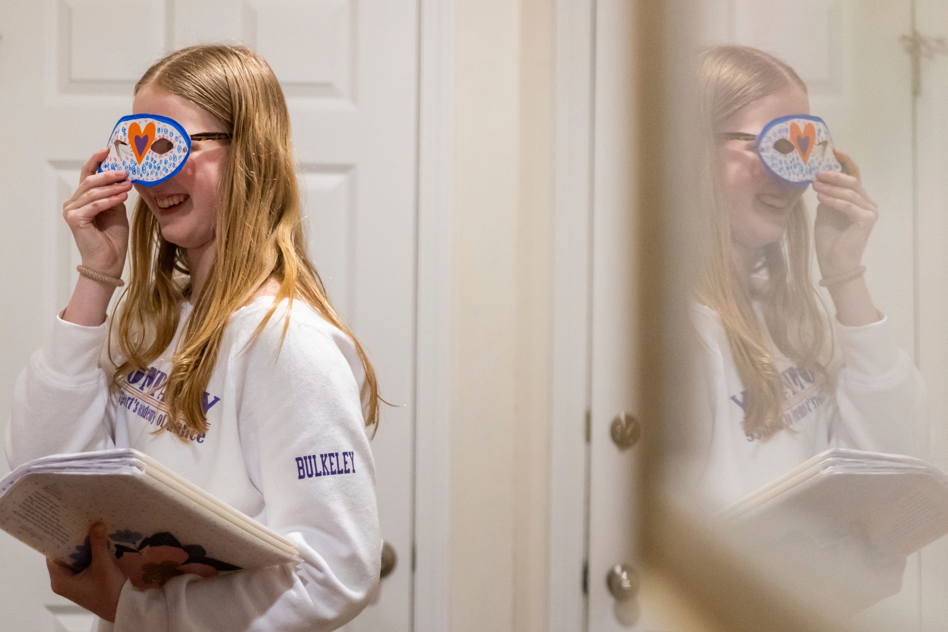 Kate Bulkeley shows her sister, Sutton, a mask she made in school, Friday, Feb. 16, 2024, in Westport, Conn. It is hard to be a teenager today without social media. For those trying to stay off social platforms at a time when most of their peers are immersed, the path can be challenging, isolating and at times liberating. It can also be life-changing.