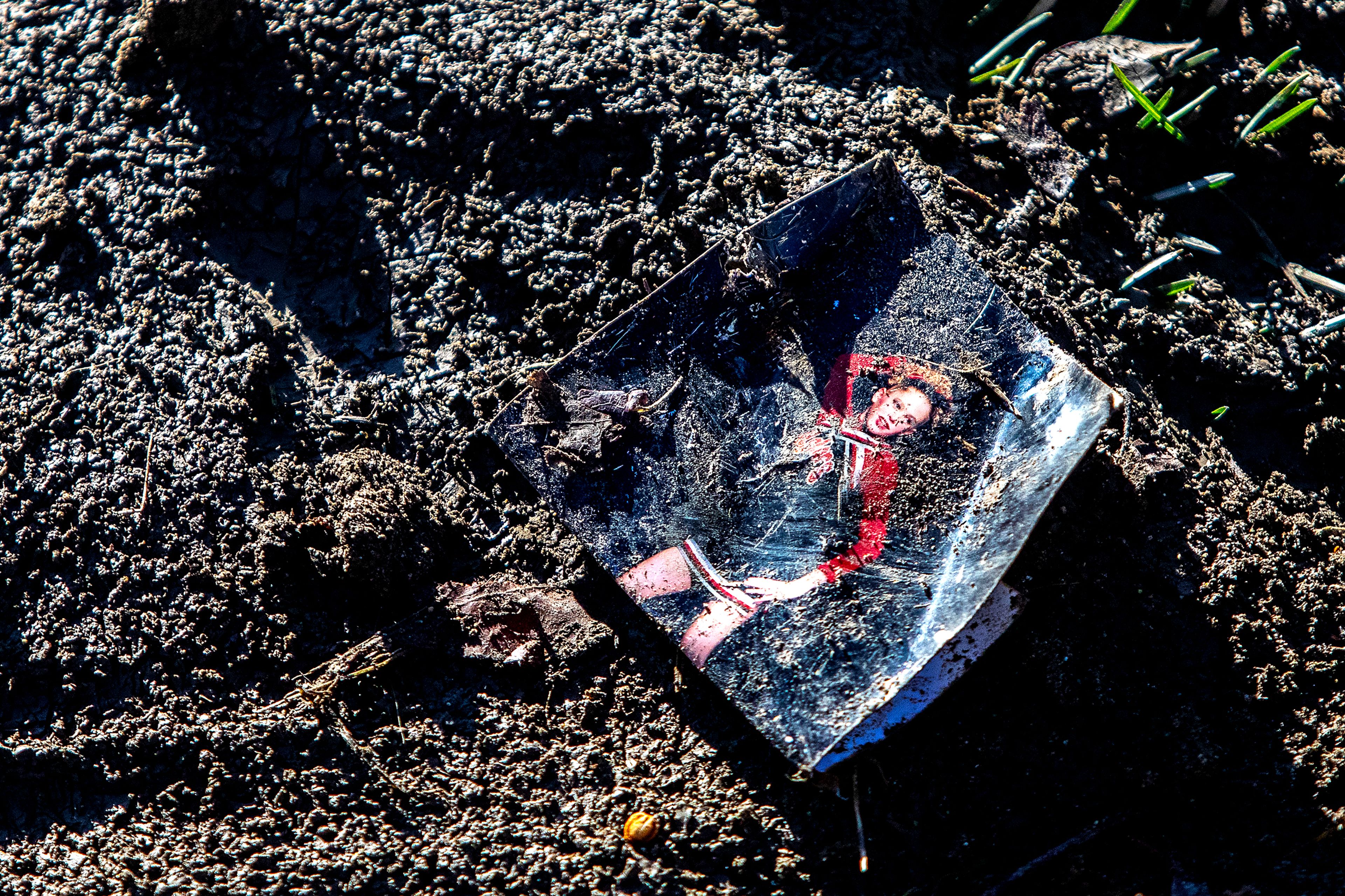 A picture lays in the mud on the outskirts of Sunset Park Monday in Lewiston.