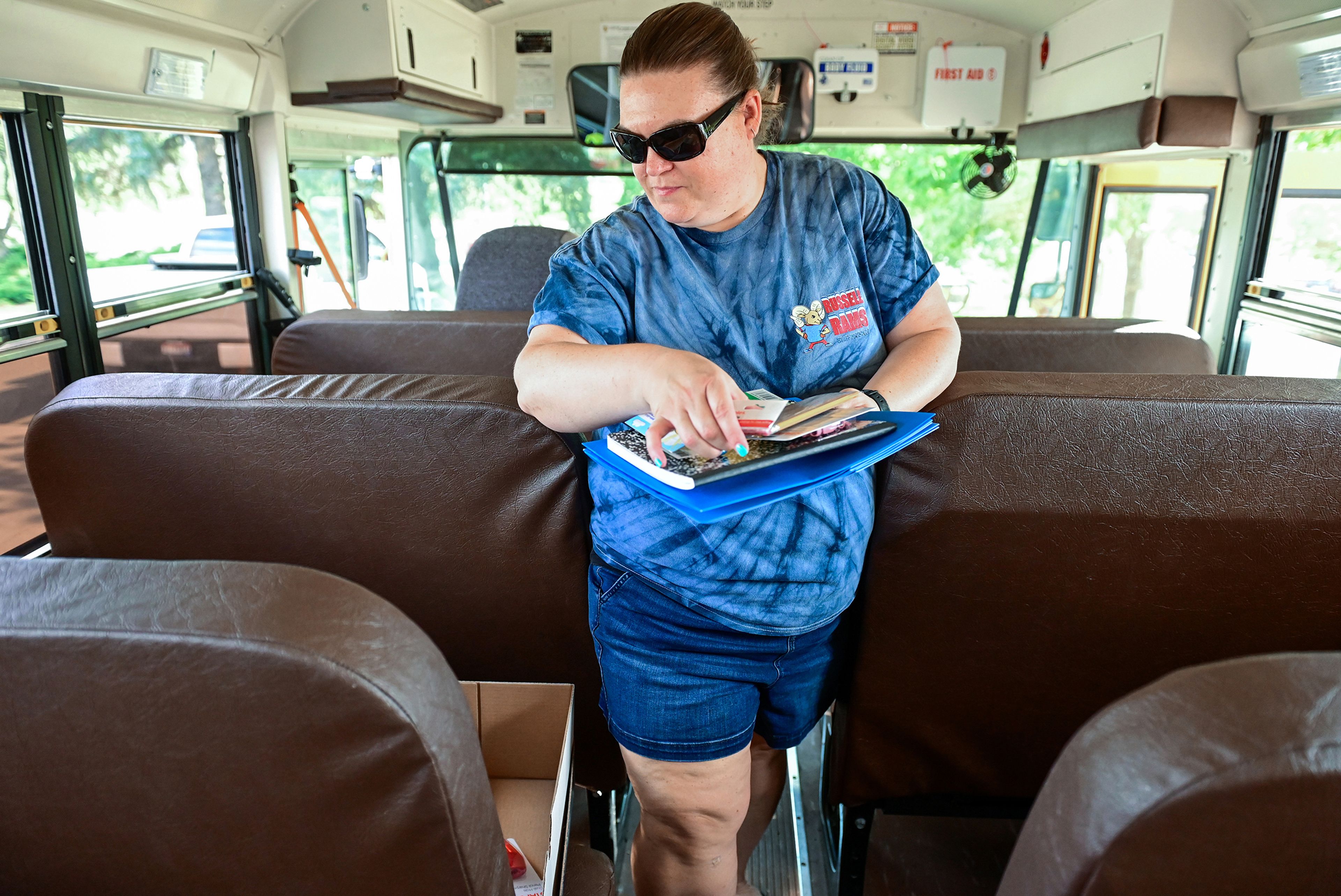 West Park Elementary principal Marianne Sletteland walks down the aisle of a Moscow school district bus to organize a school supplies donation into boxes on Thursday in Moscow as part of the Stuff the Bus school supplies drive.