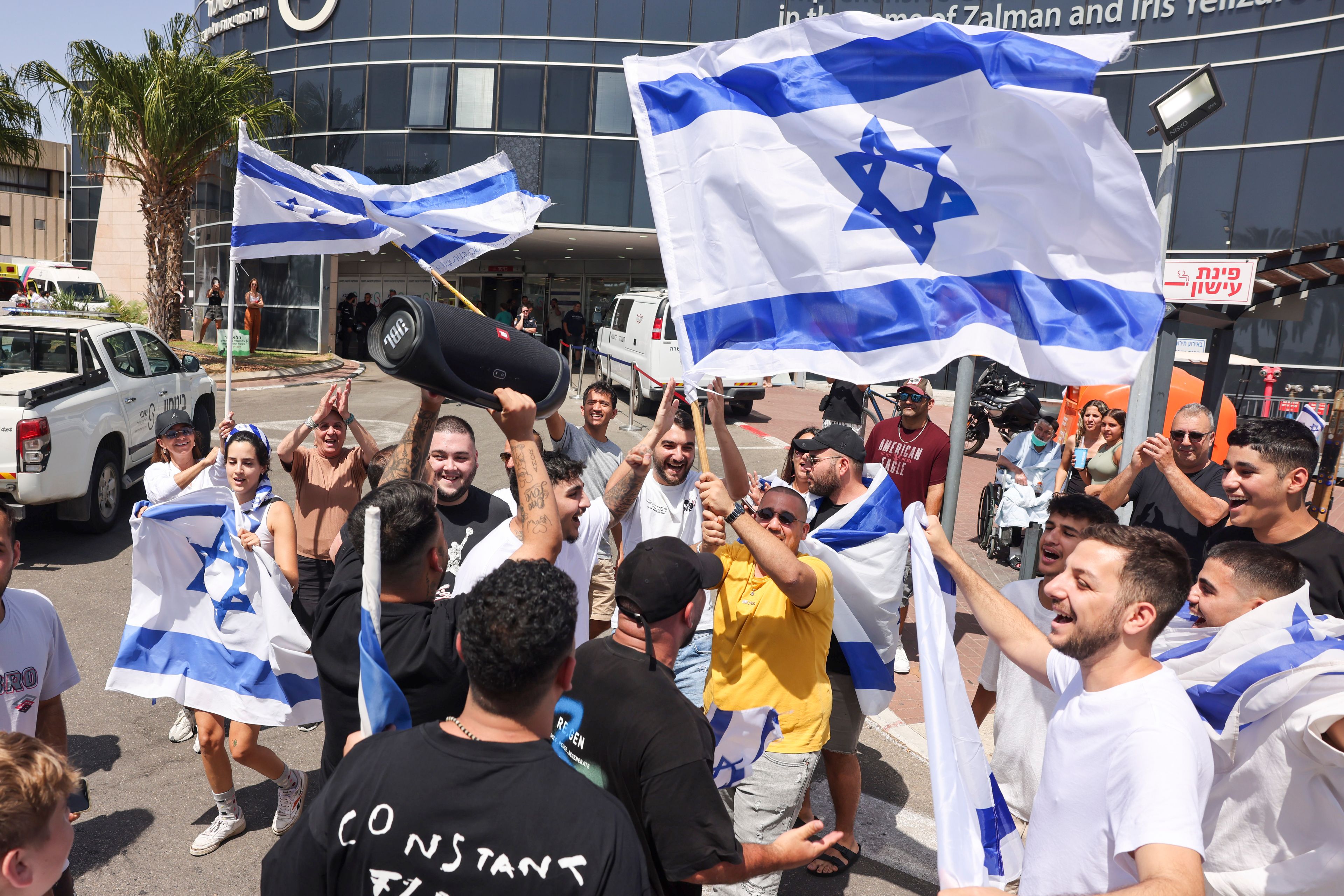 People wave Israeli flags as they celebrate after hostages who were kidnapped in a Hamas-led attack on Oct. 7. were rescued from Gaza Strip, at the Sheba Medical Center in Ramat Gan, Israel, Saturday, June 8, 2024. Israel says it has rescued four hostages who were kidnapped in a Hamas-led attack on Oct. 7. It is the largest such hostage recovery operation since the war with Hamas began in Gaza. (AP Photo/Tomer Appelbaum)