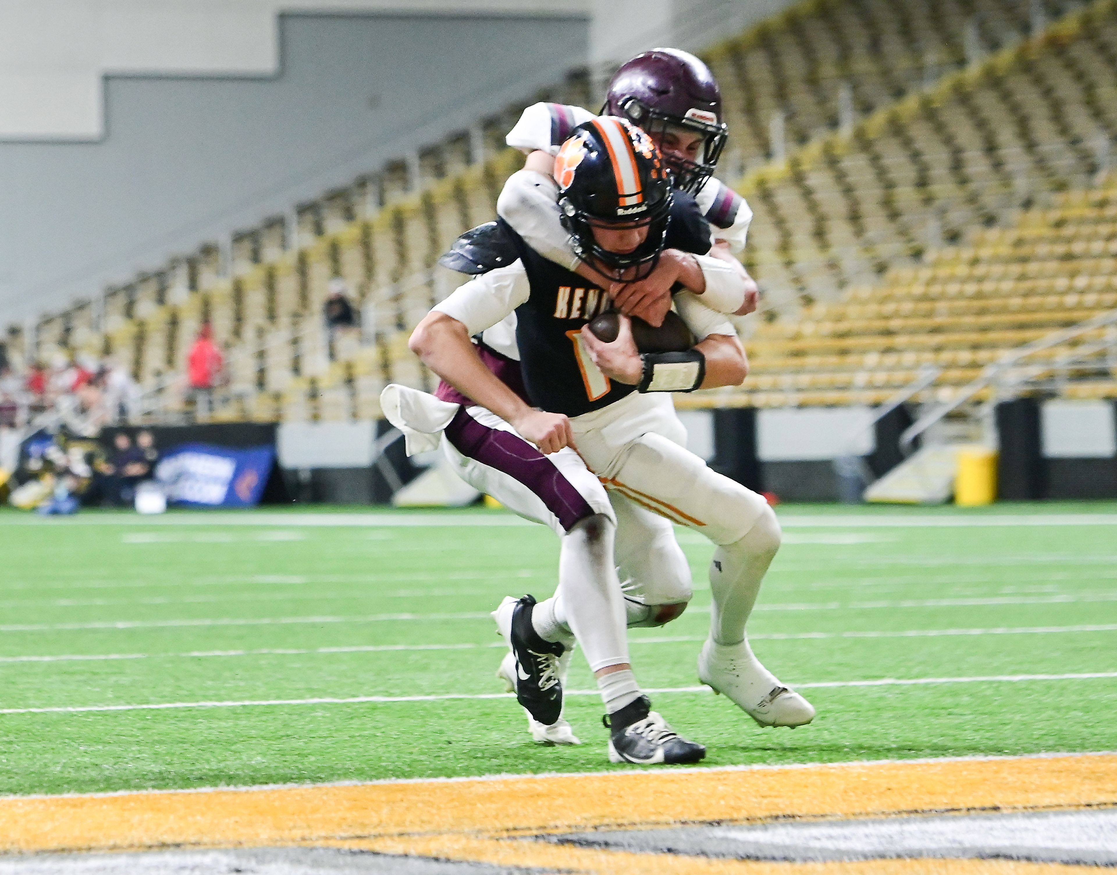 Kendrick’s Maddox Kirkland carries the ball into the end zone while being grabbed by Kamiah’s Dave Kludt during an Idaho Class 2A state quarterfinal game at the P1FCU Kibbie Dome in Moscow.