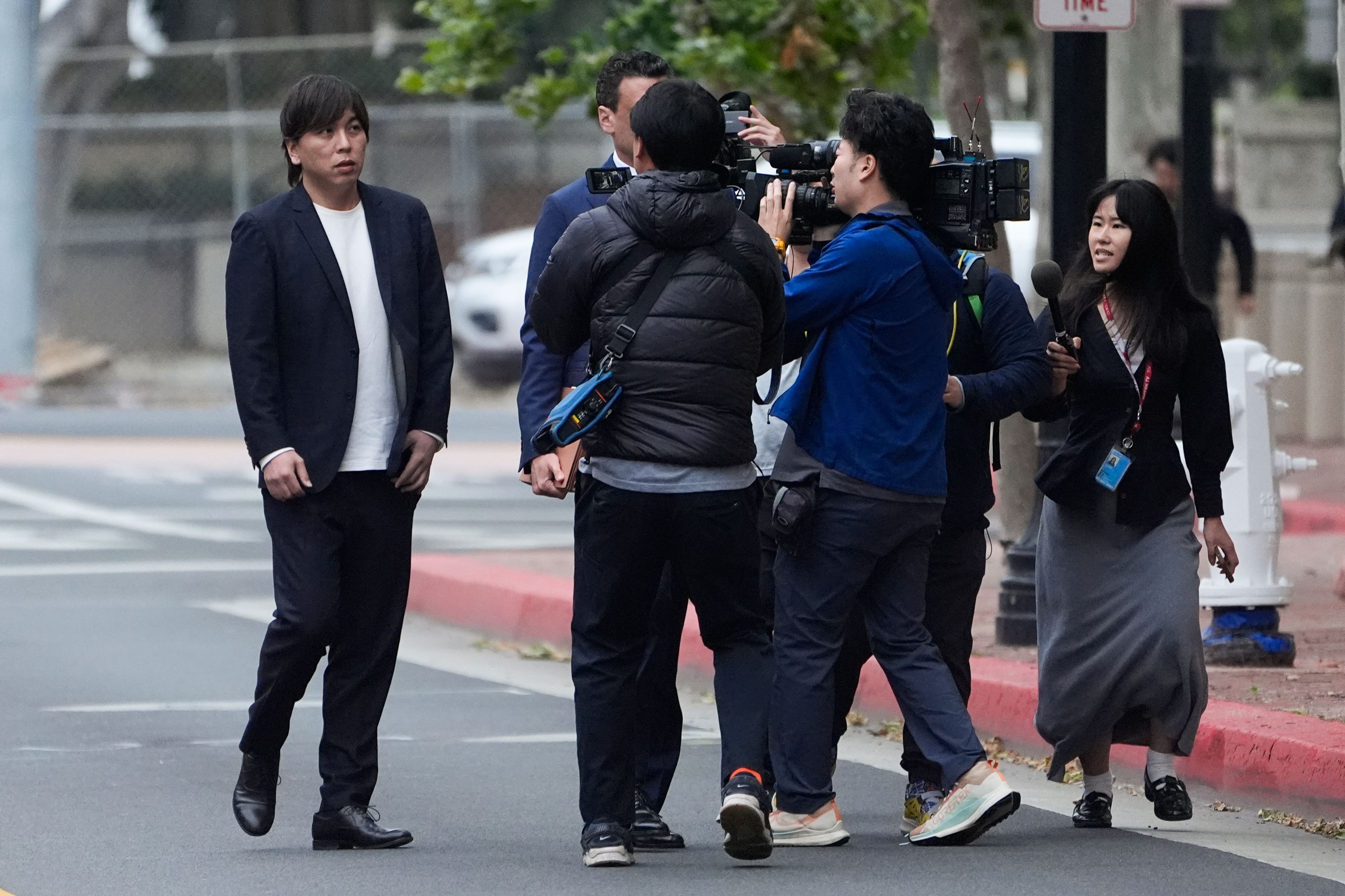 Ippei Mizuhara, left, the former longtime interpreter for the Los Angeles Dodgers baseball star Shohei Ohtani, arrives at federal court in Los Angeles, Tuesday, June 4, 2024. Mizuhara is scheduled to plead guilty Tuesday to bank and tax fraud in a sports betting case where he is expected to admit to stealing nearly $17 million from the Japanese baseball player.