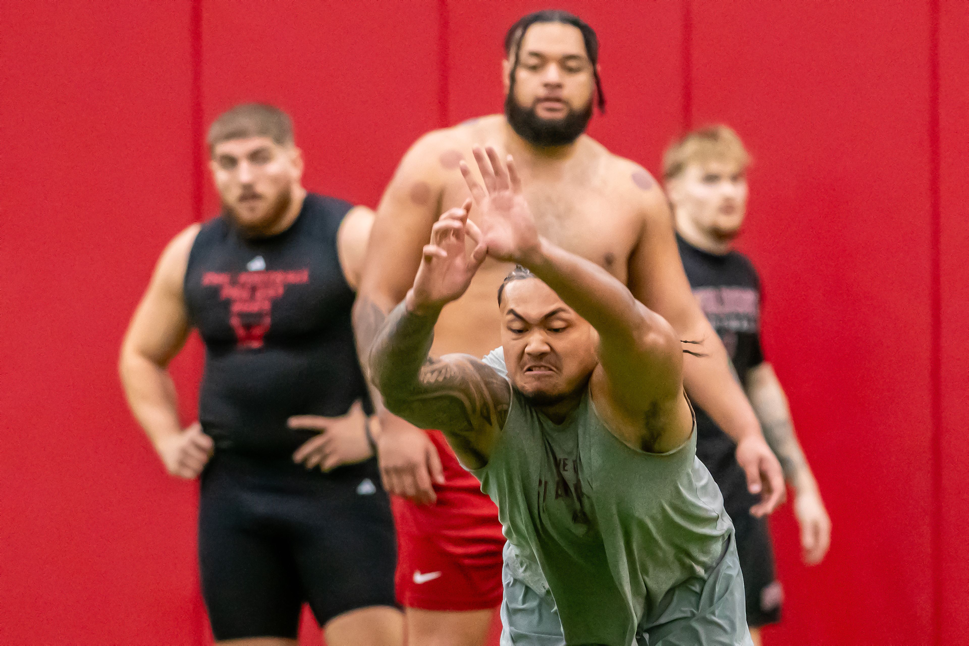 Washington State edge Nusi Malani prepares to jump forward for the broad jump test as others look on during WSU's Pro Day on Friday in Pullman.