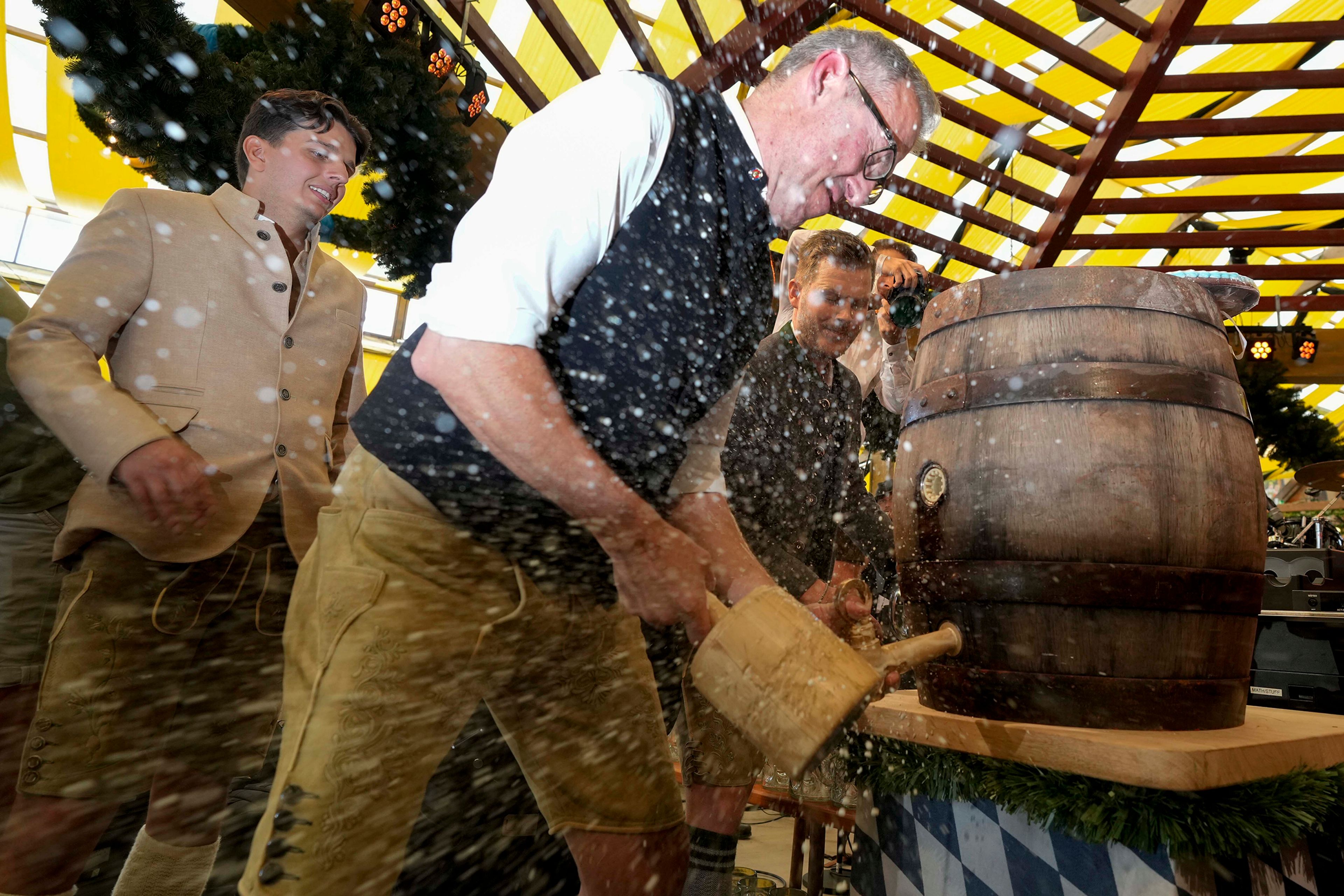 Paulaner brewmaster Christian Dahncke taps the first beer barrel on the opening day of the 189th 'Oktoberfest' beer festival in Munich, Germany, Saturday, Sept. 21, 2024. (AP Photo/Matthias Schrader),