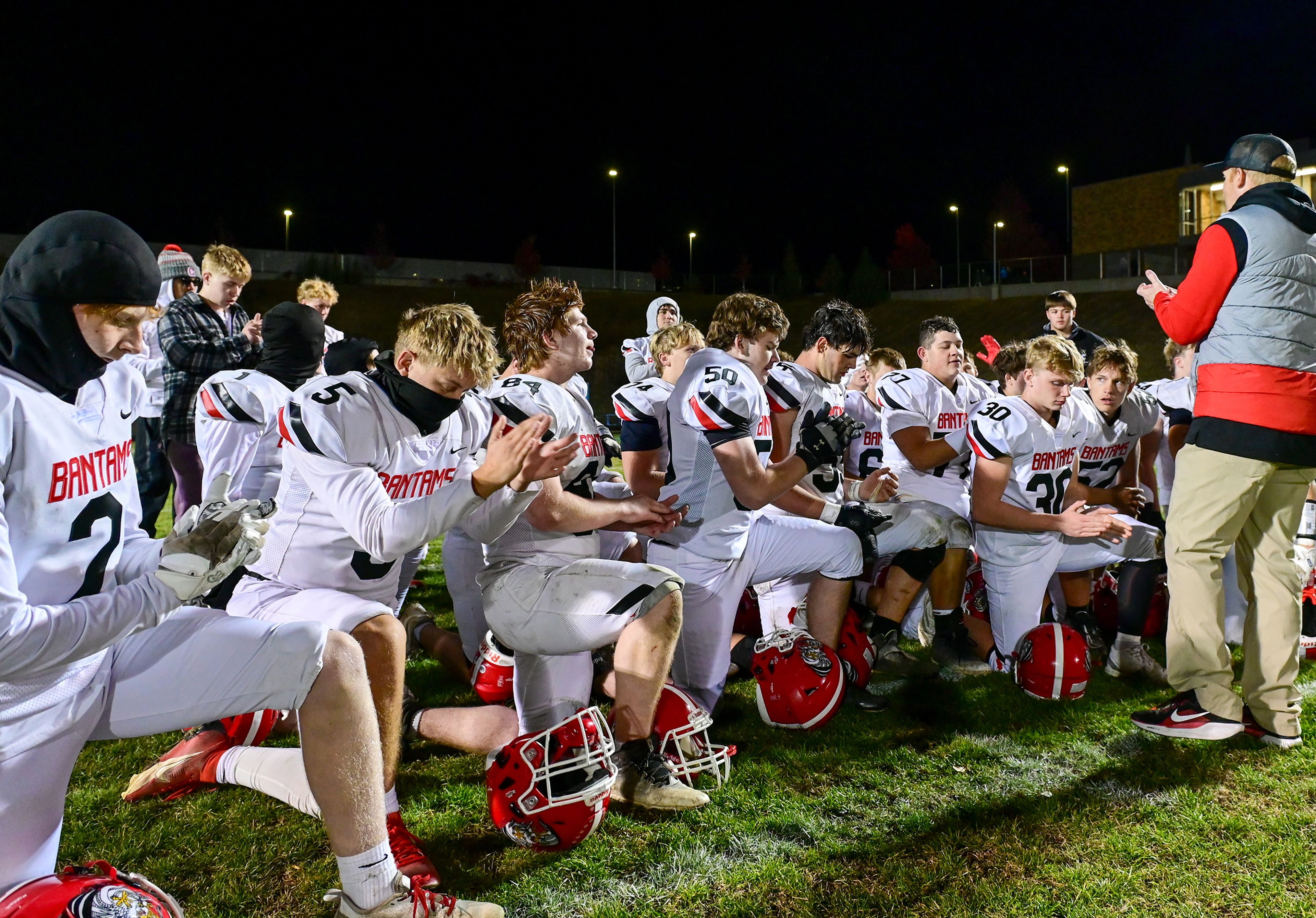 Clarkston players clap from a huddle with head head Brycen Bye after their win over Pullman Friday in Pullman.,