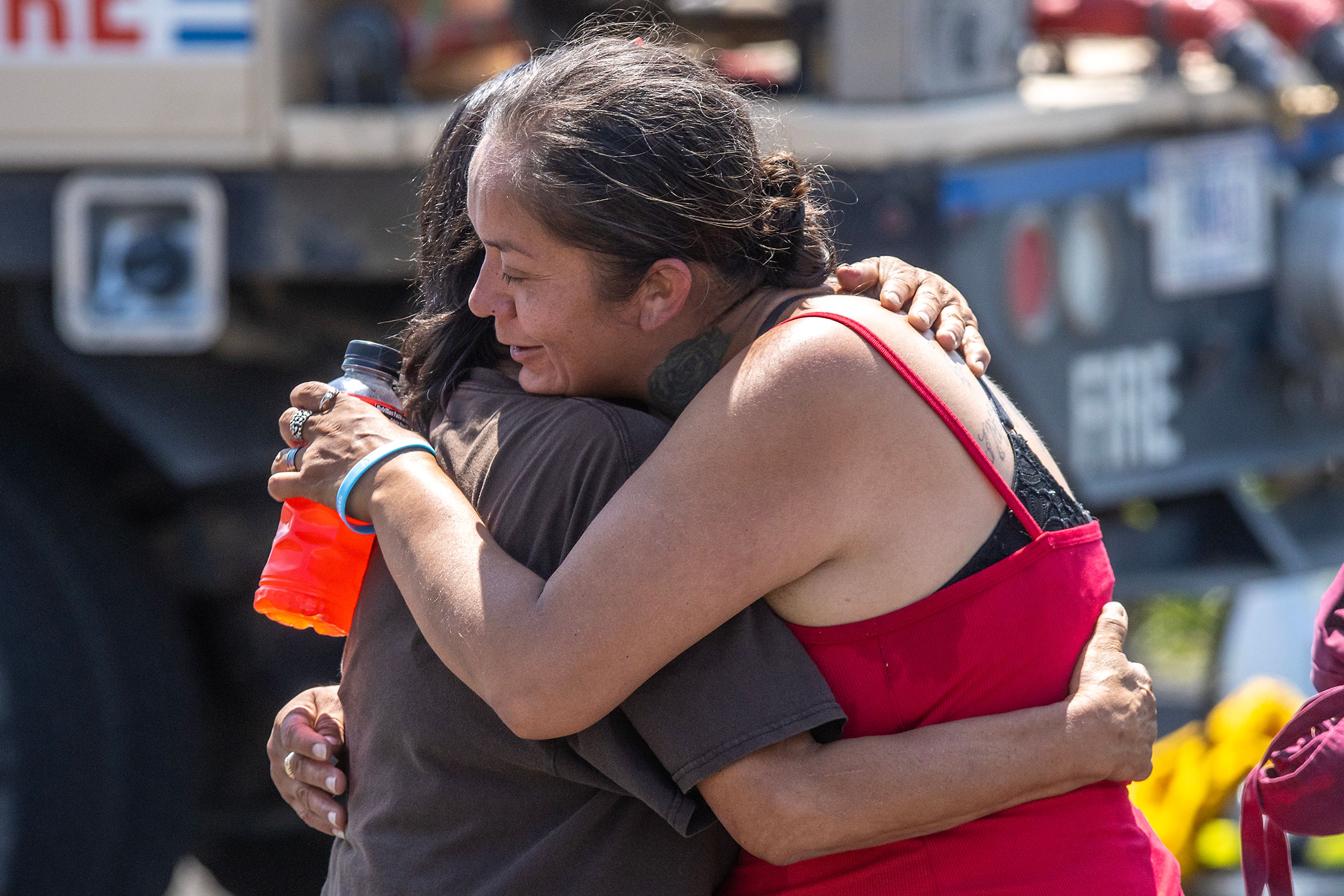 People embrace as firefighters work to finish putting out a structure fire Friday on Lolo Street in Lapwai.