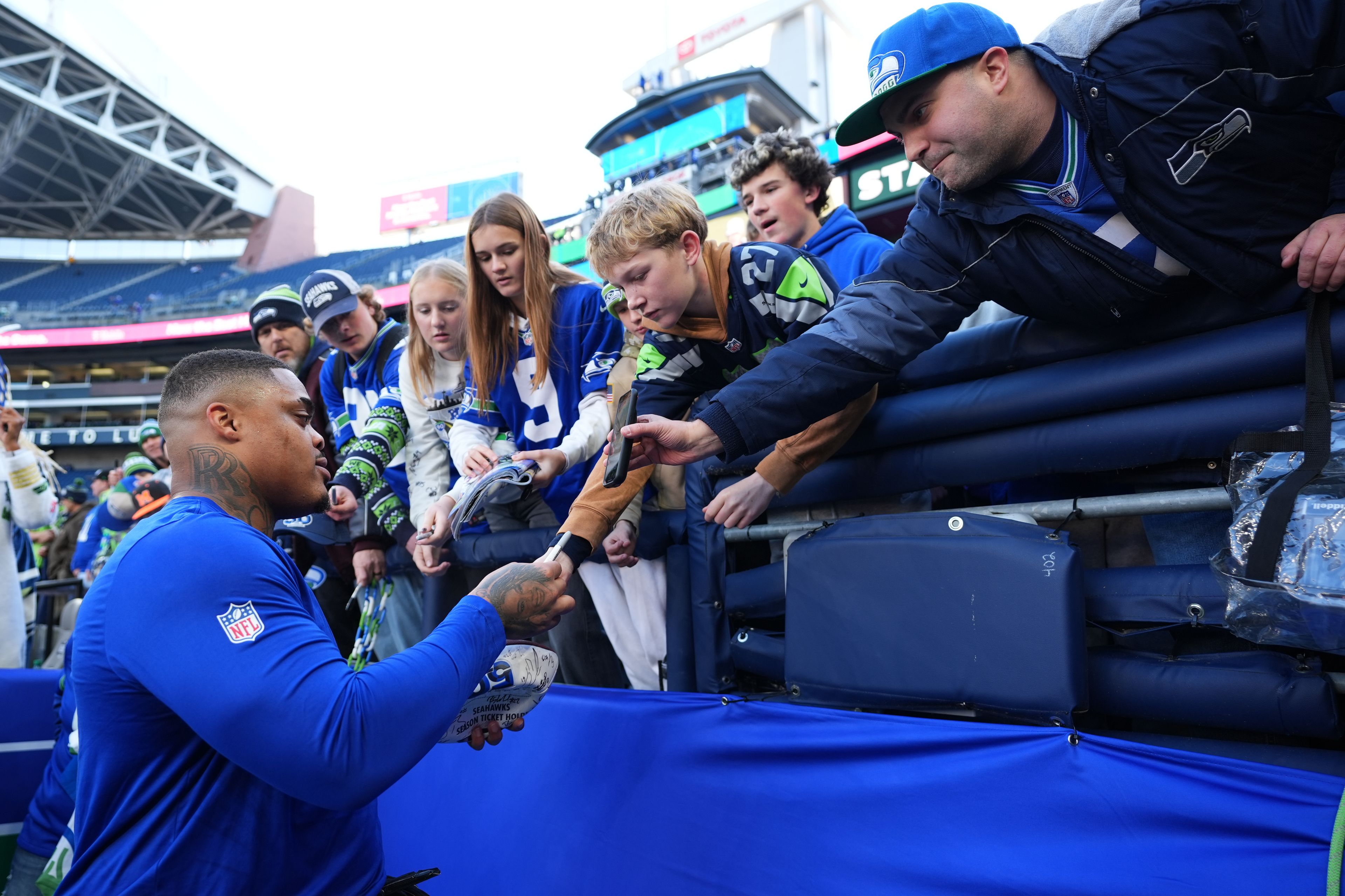 Seahawks defensive tackle Byron Murphy II signs autographs for fans before a game against the Vikings on Nov. 30 in Seattle.