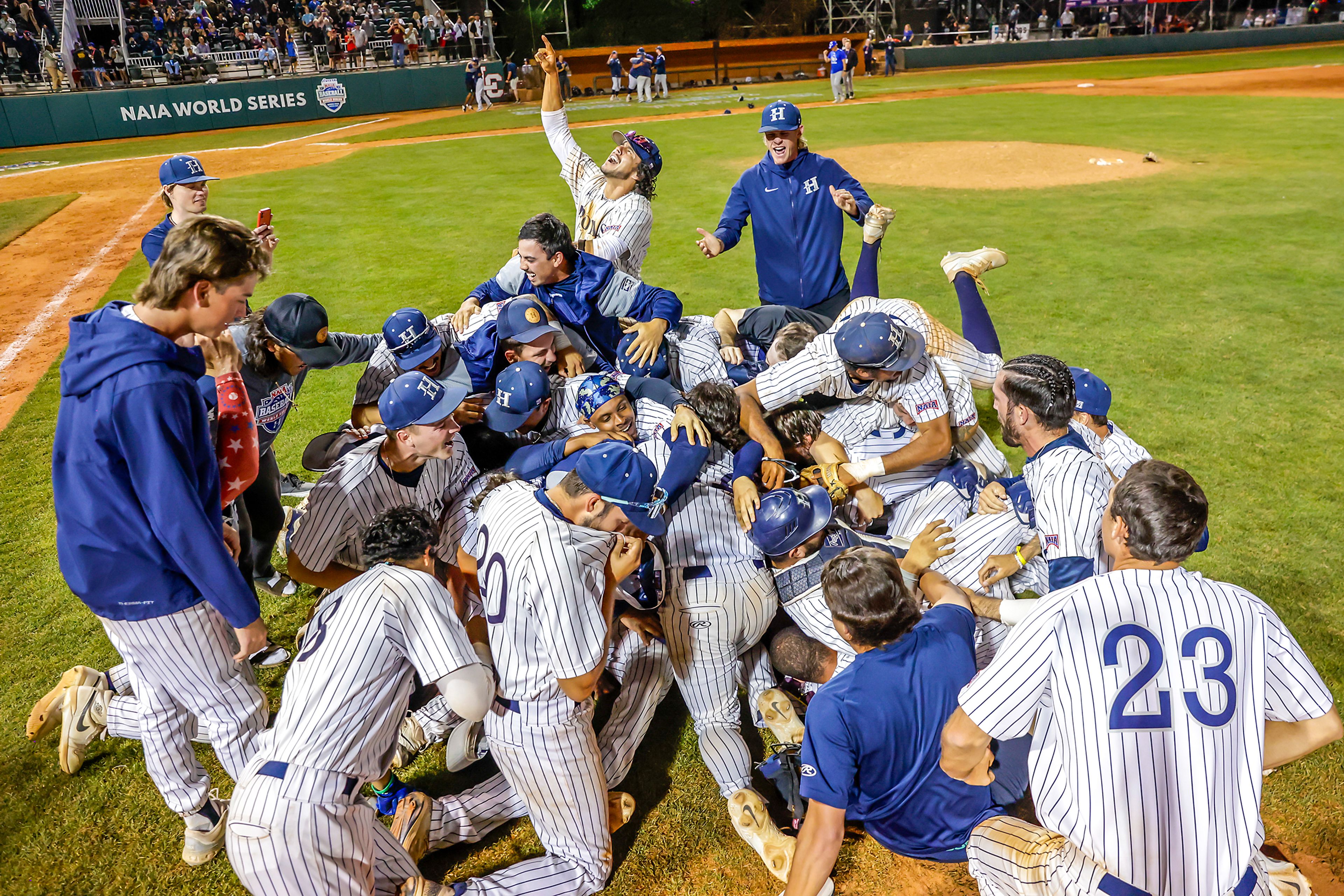 Hope International dogpiles after defeating Tennessee Wesleyan 13-6 in Game 19 of the NAIA World Series at Harris Field Friday in Lewiston.