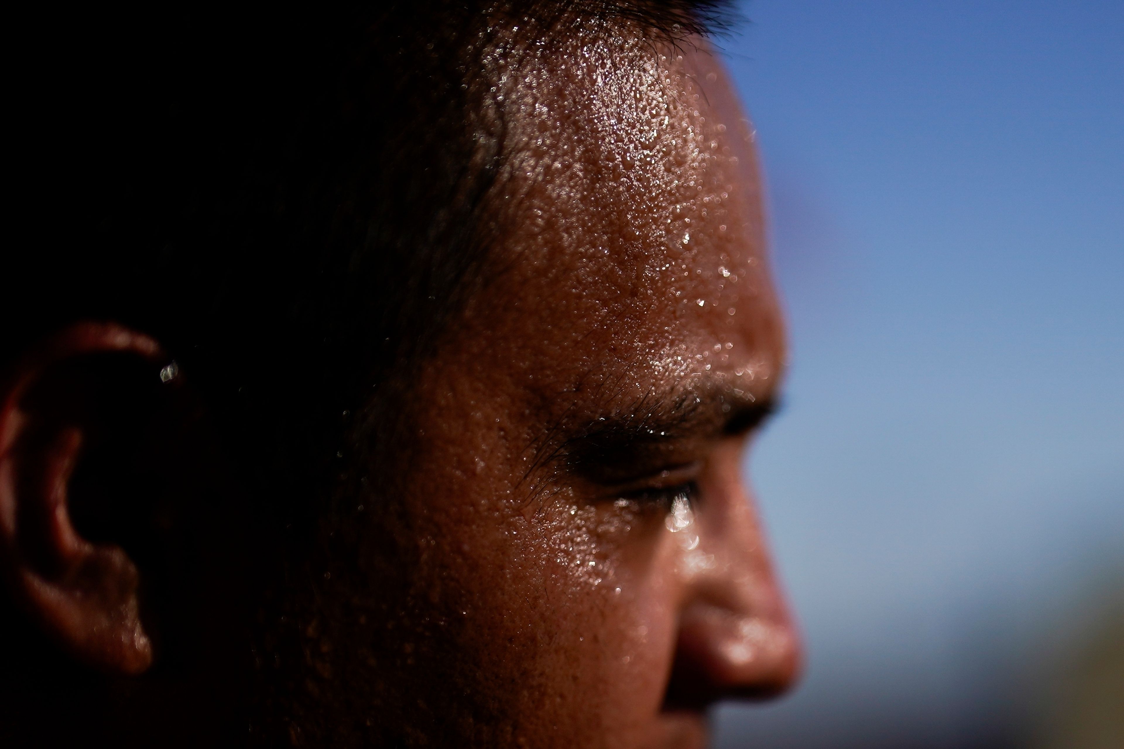 FILE - Juan Carlos Biseno sweats as he dances to music from his headphones as afternoon temperatures reach 115 degrees on July 19, 2023, in Calexico, Calif. The death certificates of more than 2,300 people who died in the United States last summer mention the effects of excessive heat, the highest number in 45 years of records, according to an Associated Press analysis of Centers for Disease Control and Prevention data. With May already breaking heat records, 2024 could be even deadlier. (AP Photo/Gregory Bull, File)