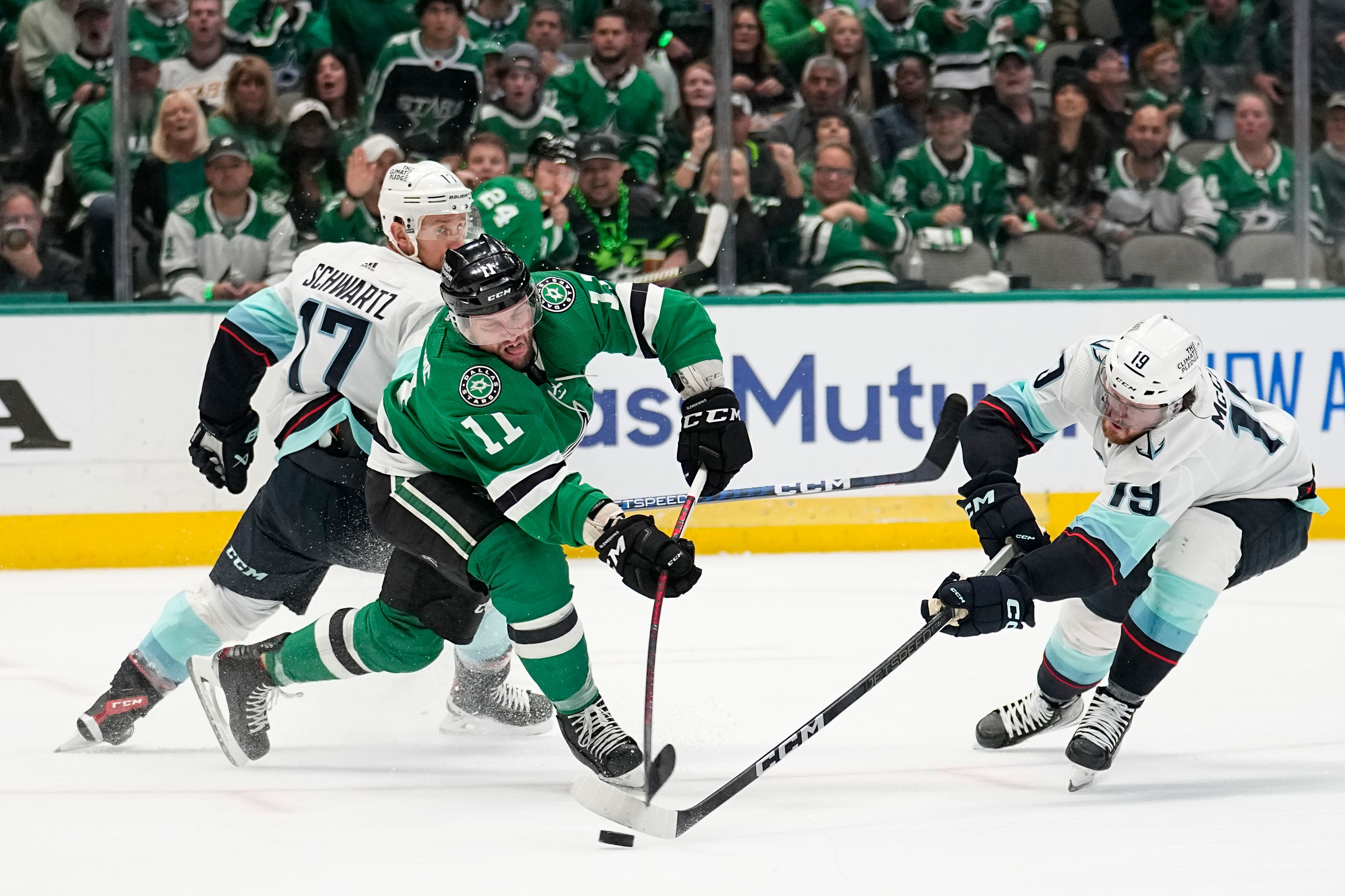 Dallas Stars center Luke Glendening (11) takes a shot at the net after gaining control of a loose puck between Seattle Kraken's Jaden Schwartz (17) and Jared McCann (19) in the first period of Game 7 of an NHL hockey Stanley Cup second-round playoff series, Monday, May 15, 2023, in Dallas. (AP Photo/Tony Gutierrez)