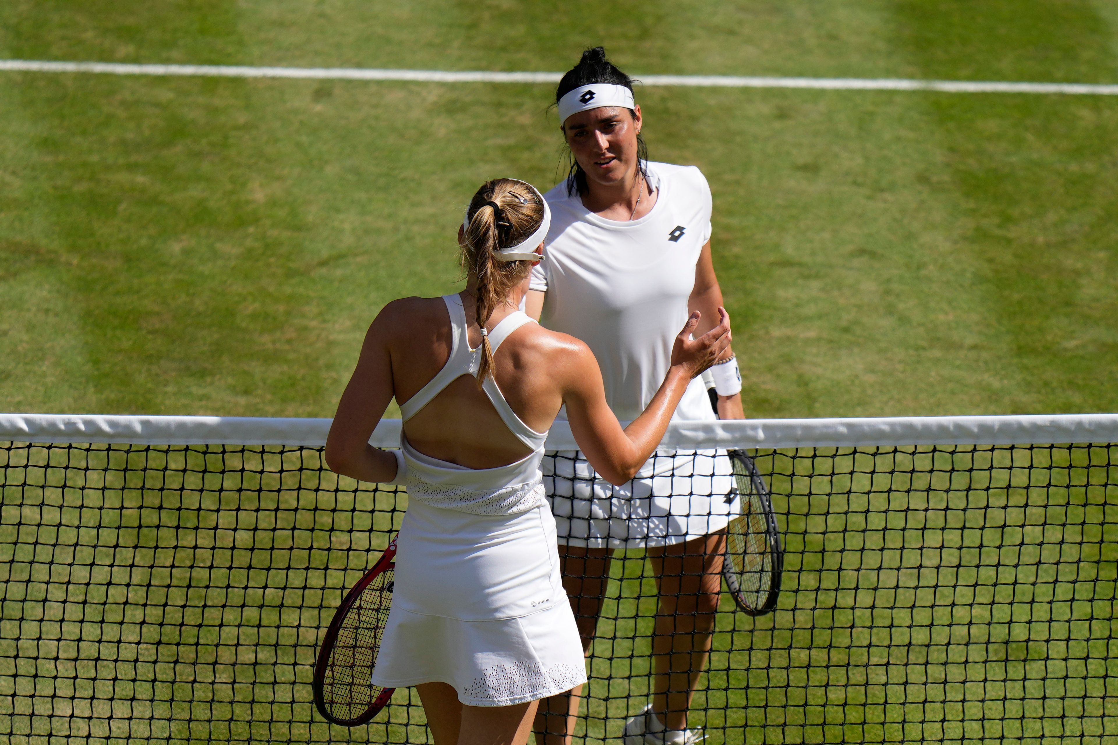 Kazakhstan's Elena Rybakina, foreground shakes hands withTunisia's Ons Jabeur after beating her in the final of the women's singles on day thirteen of the Wimbledon tennis championships in London, Saturday, July 9, 2022. (AP Photo/Alastair Grant)