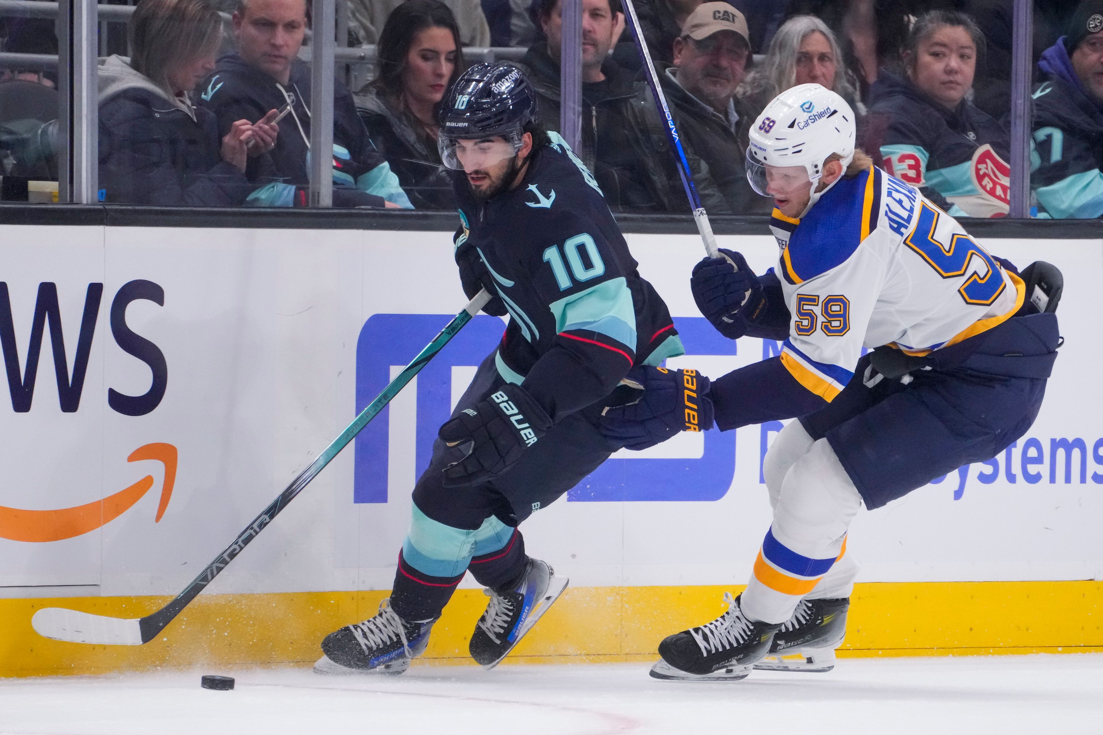 Kraken center Matty Beniers (10) moves the puck against St. Louis Blues center Nikita Alexandrov (59) during the first period of a game Friday in Seattle.