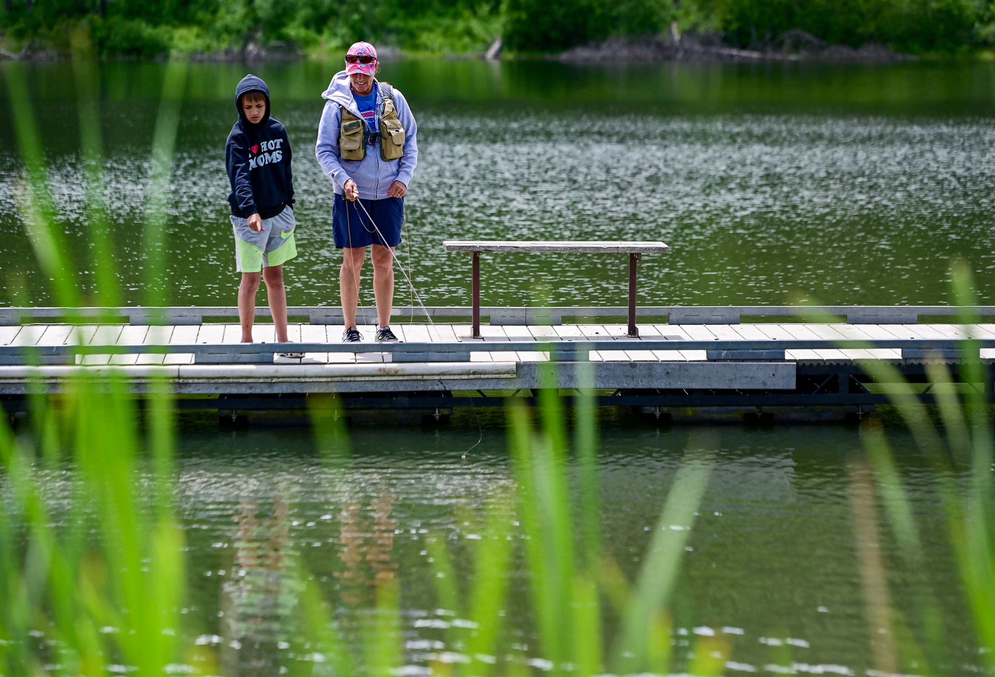 Dominik Burton, 12, of Chicago, points out fish swimming close by to aunt Robin Barnes, of Moscow, from a pier at the Spring Valley Reservoir outside of Troy on Friday.