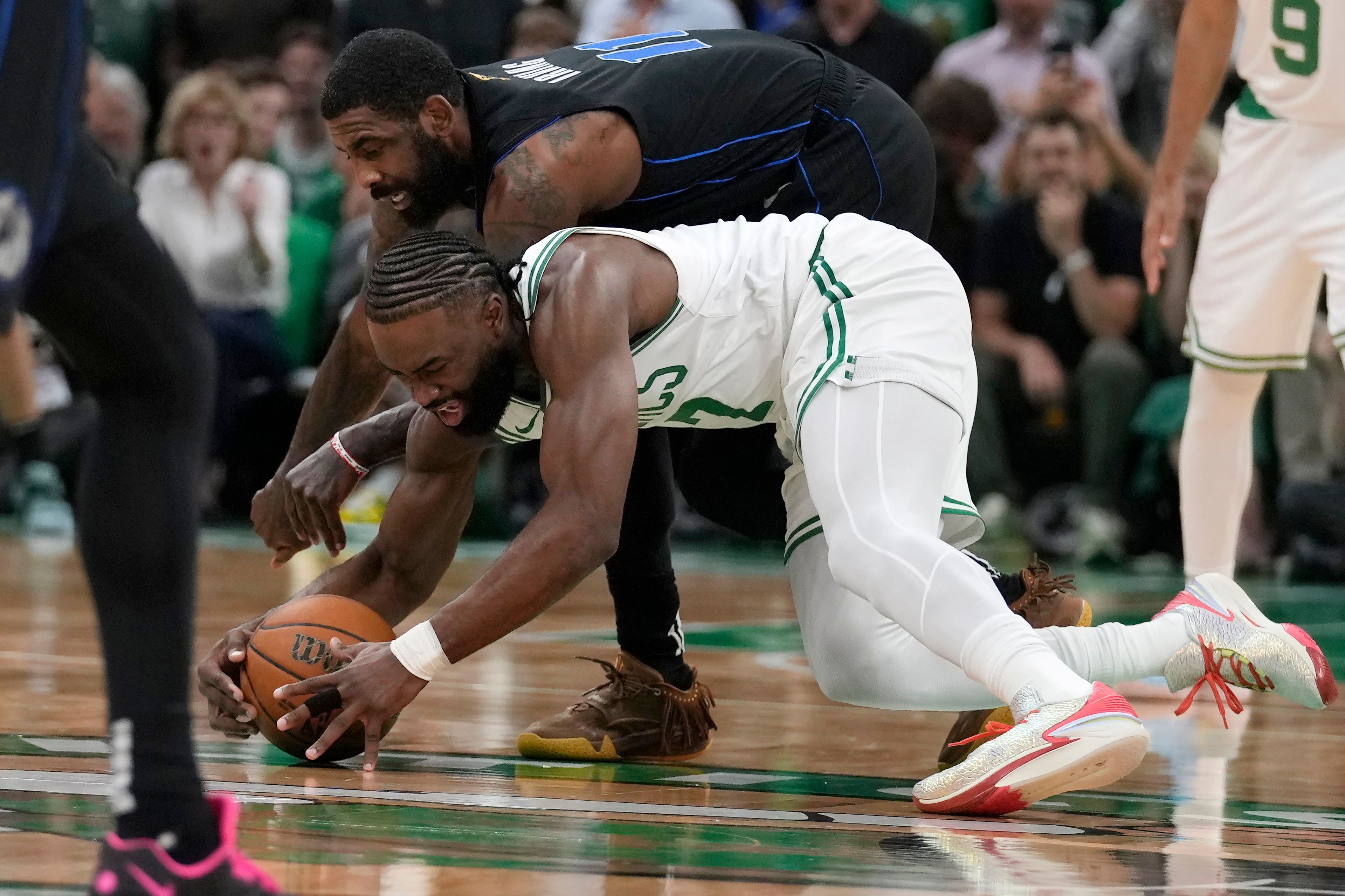 Boston Celtics guard Jaylen Brown, fornt, and Dallas Mavericks guard Kyrie Irving vie for the ball during the first half of Game 1 of basketball's NBA Finals, Thursday, June 6, 2024, in Boston.