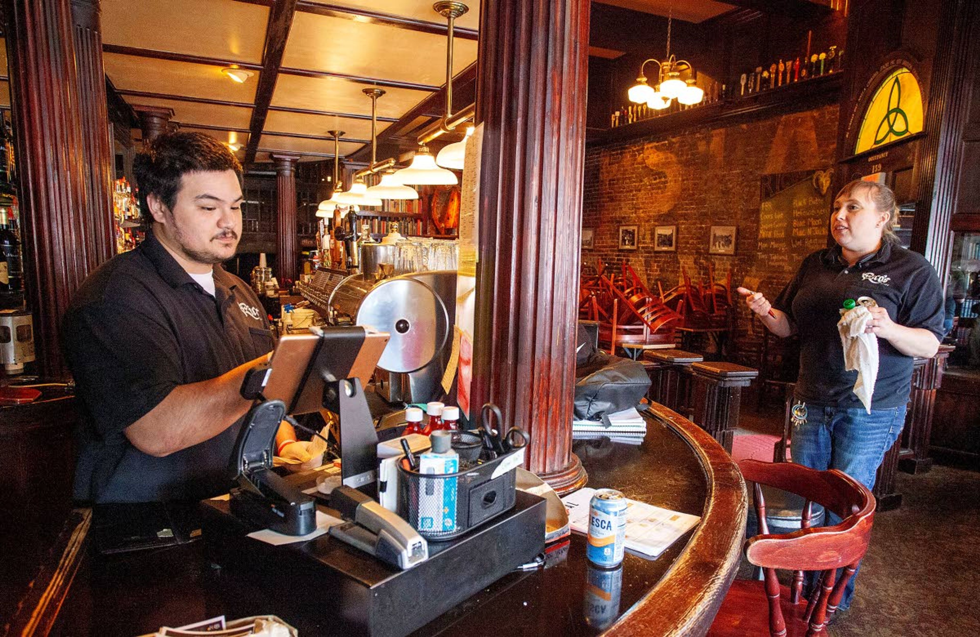 Manager John Landers, (left) and owner Tawny Szumlas work Thursday at Rico’s Public House in downtown Pullman. The pub opened in 1909 and moved to its current location on Main Street in 1927. Rico’s is open for takeout and delivery of food and drinks in sealed bottles or cans.