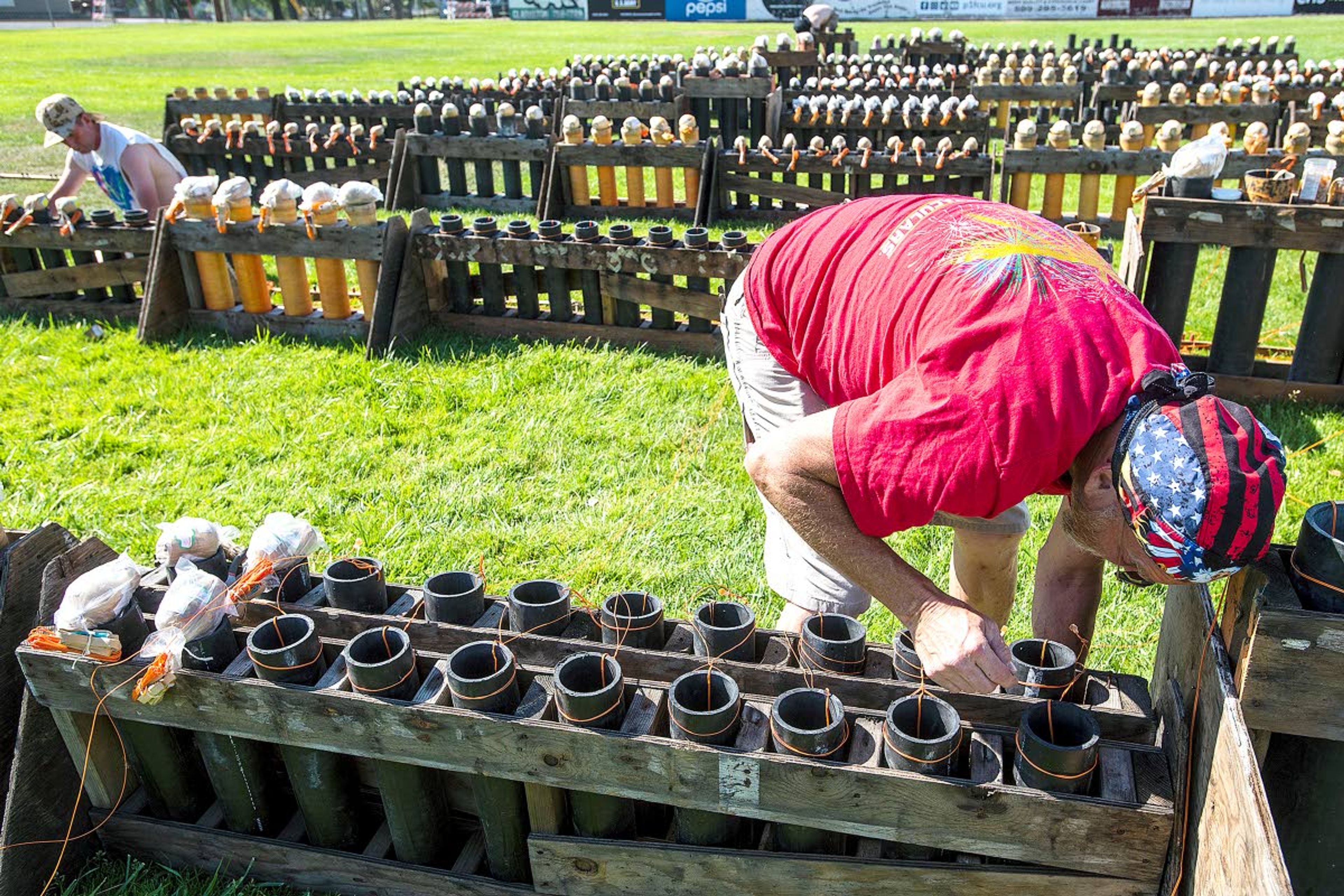 Above: The Thursday evening air turns a bright red while fireworks explode over Clarkston as people sit along the Lewiston Levee Parkway Trail to watch the Community Spirit 34th Annual Fireworks Show 2019 from across the Snake River.LEFT: Pyro technicians Jeff Casali (right), Mike McCann (left) and Zak King set up for the annual Fourth of July fireworks show at Adams Field in Clarkston on Thursday morning.